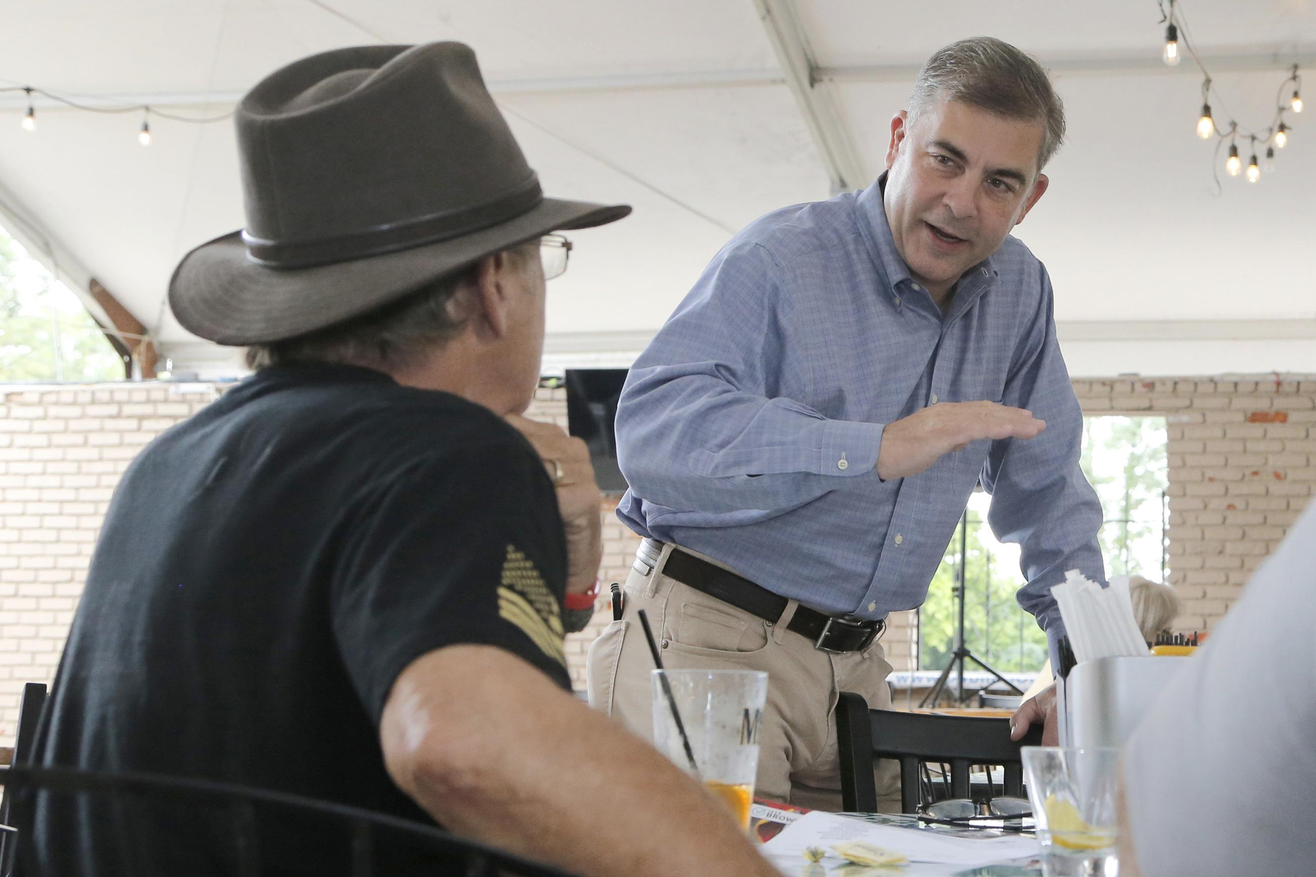 FILE — In this file photo from Aug. 9, 2021, Mike Carey, Republican candidate for the 15th Congressional District of Ohio, talks to a supporter before a Republican club meeting in Powell, Ohio. Carey is facing Democrat Allison Russo in the election on Tuesday, Nov. 2, 2021. (AP Photo/Jay LaPrete, File)