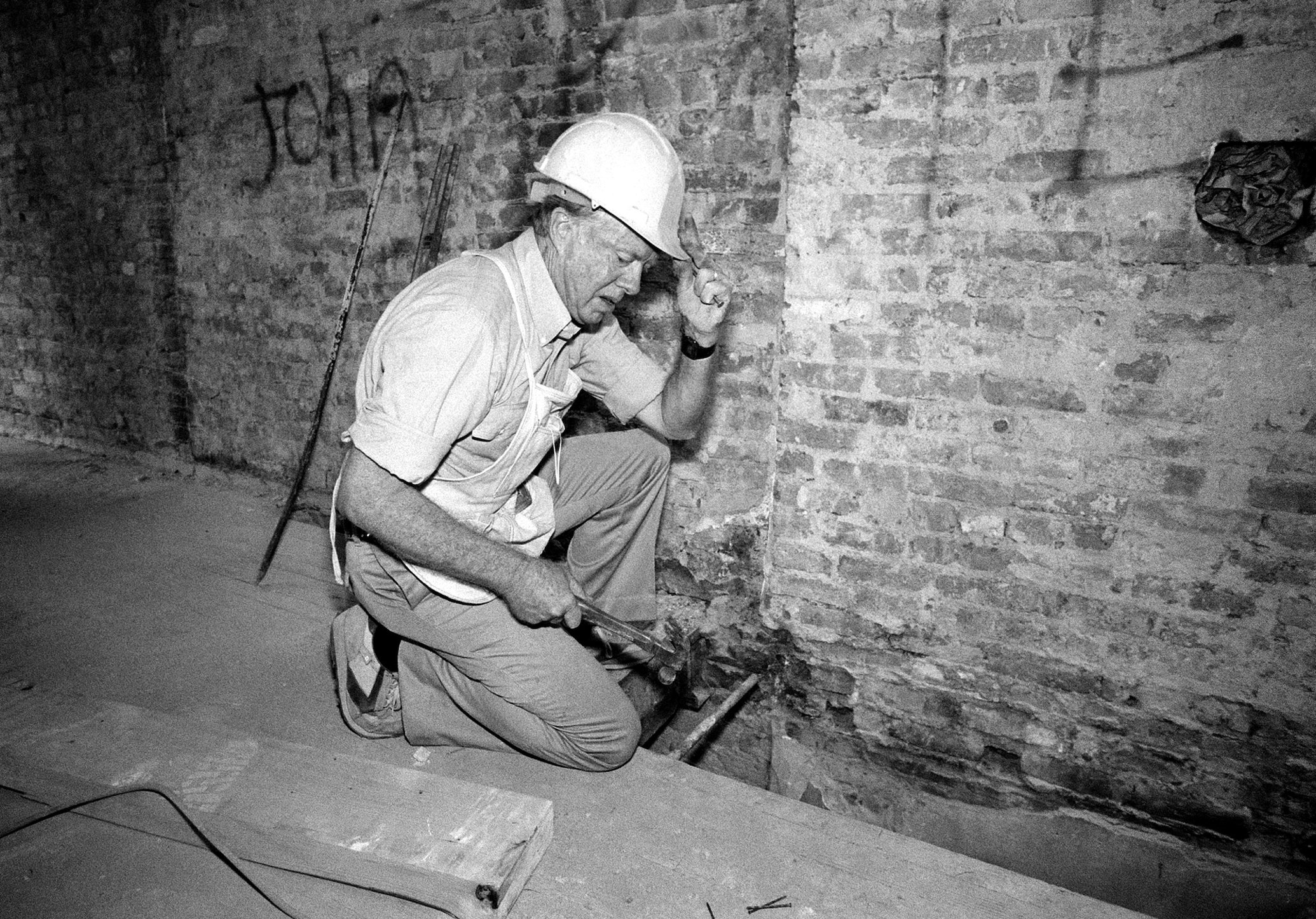 Former President Jimmy Carter working as a carpenter during renovation of a tenement building on New York's Lower East Side on Labor Day weekend, 1984. Carter, along with 50 other volunteers from Georgia, was working to build new homes for 19 families as part of a Habitat for Humanity project. (AP Photo/Mario Cabrera)