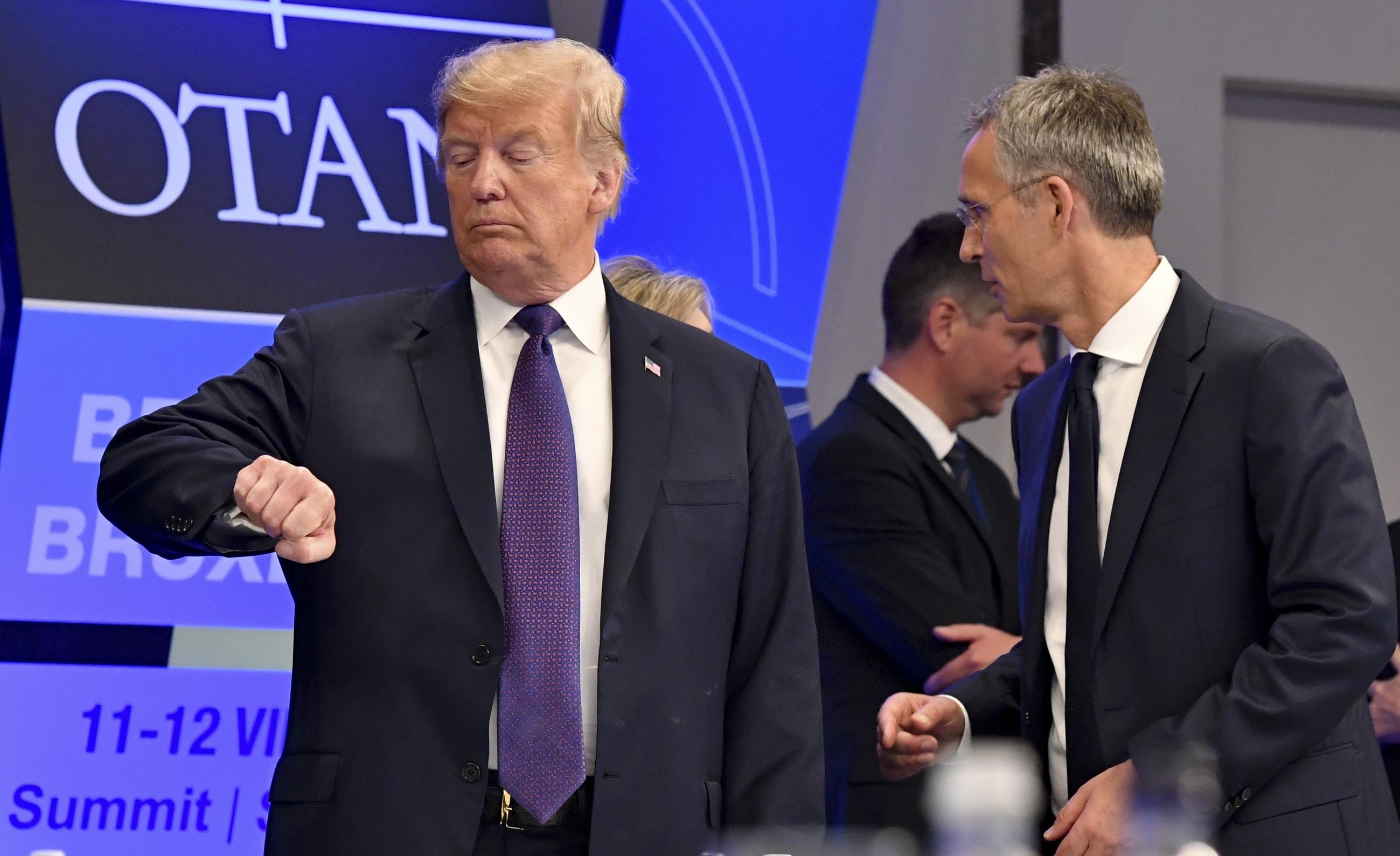 Then-President Trump checking his watch as NATO Secretary General Jens Stoltenberg stands beside him at an event in Brussels in 2018. (AP Photo/Geert Vanden Wijngaert, File)