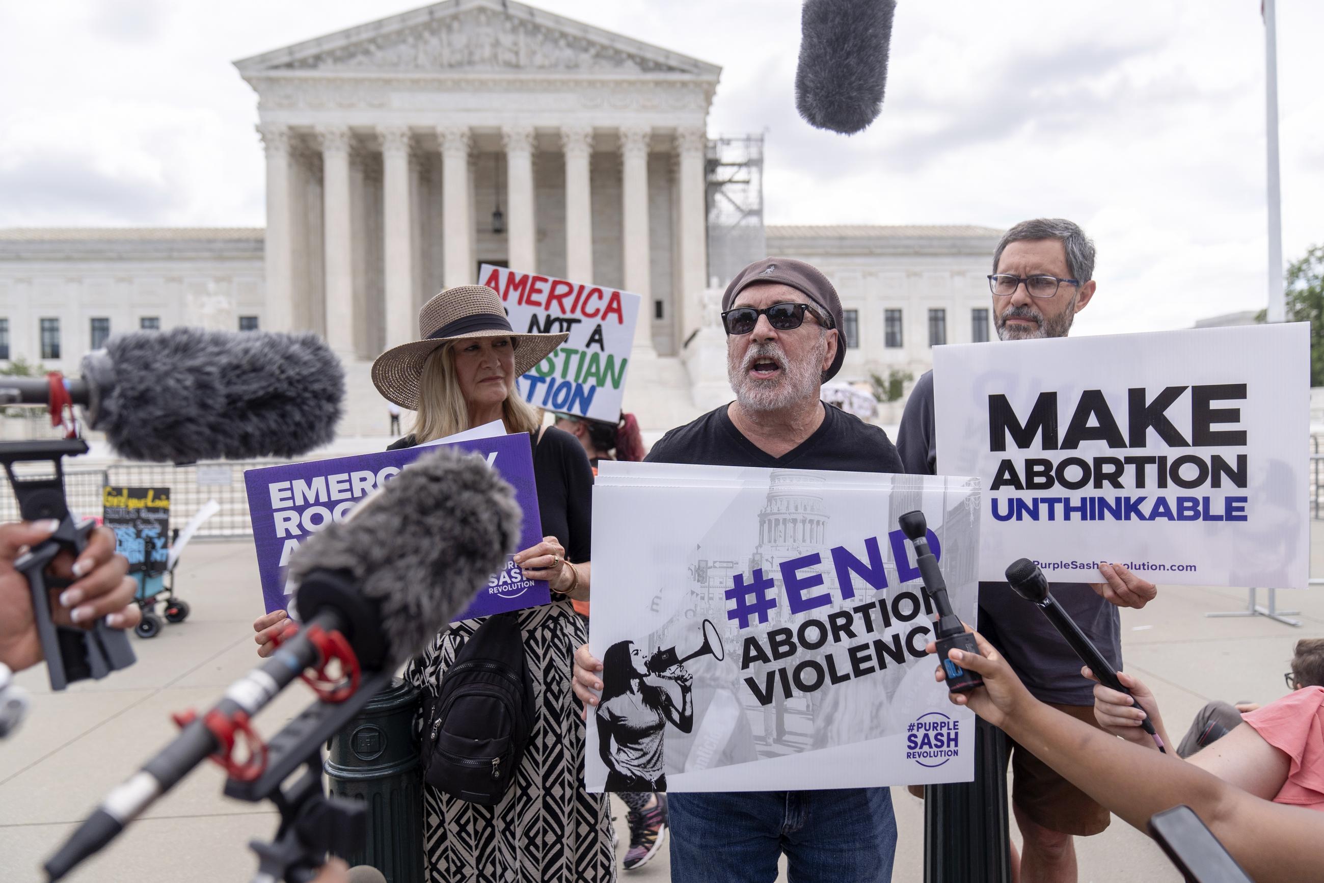 The Rev. Patrick Mahoney (center), chief strategy officer for Stanton Healthcare, an Idaho-based pregnancy center that does not provide abortions, demonstrates outside the Supreme Court on Thursday. (AP Photo/Mark Schiefelbein)