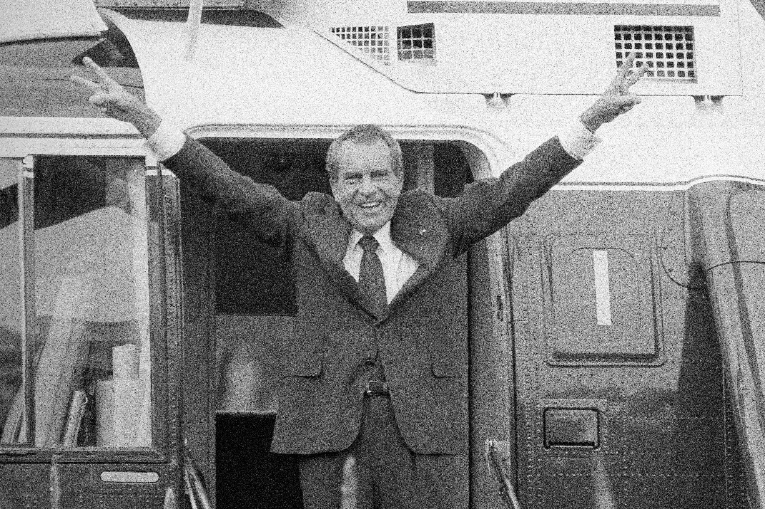 FILE - Richard Nixon says goodbye with a victorious salute to his staff members outside the White House as he boards a helicopter after resigning the presidency on Aug. 9, 1974.  (AP Photo/Bob Daugherty, File)