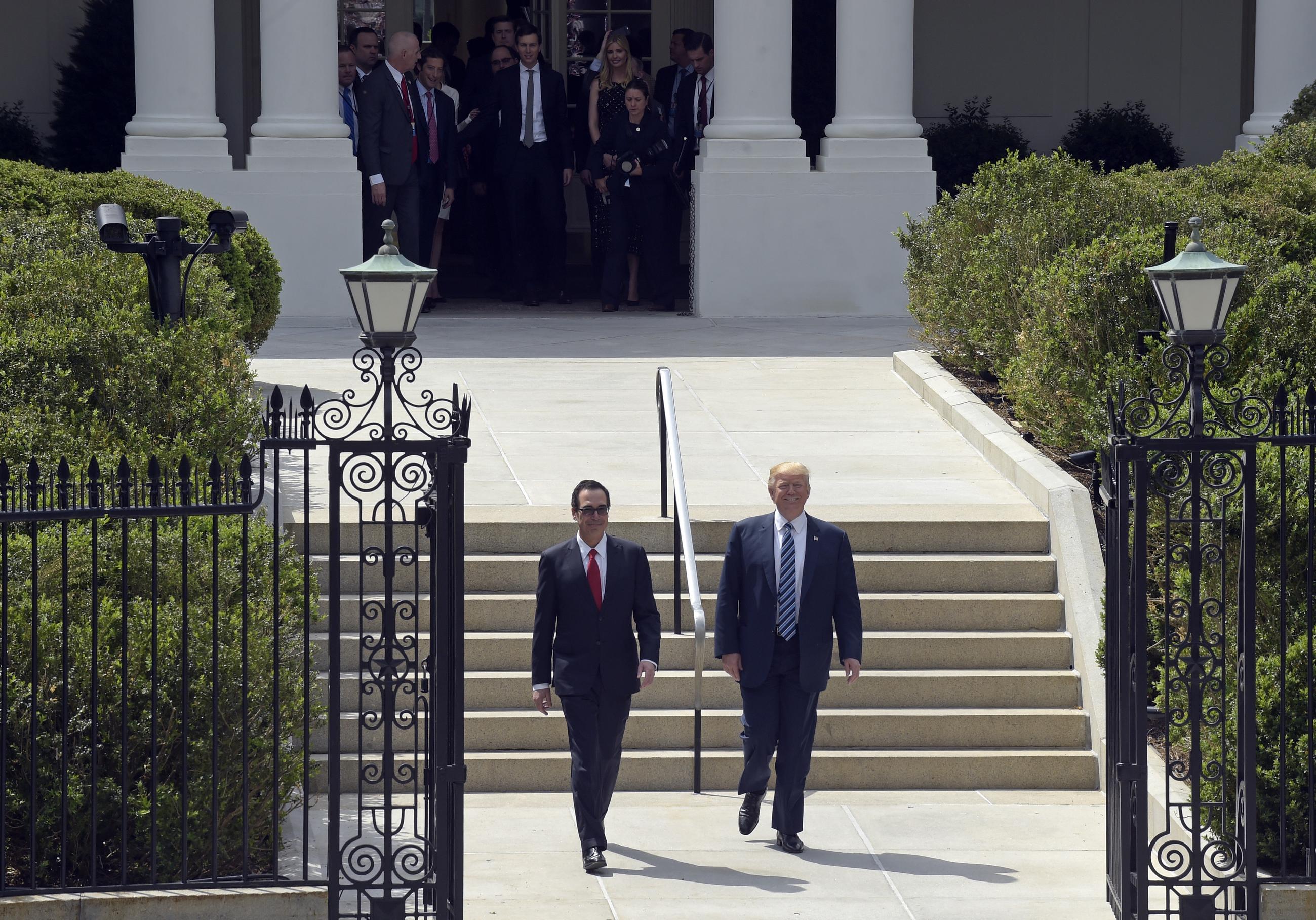 Former President Trump and former Treasury Secretary Steven Mnuchin walk from the White House to the Treasury Department in Washington, Friday, April 21, 2017. (AP Photo/Susan Walsh)