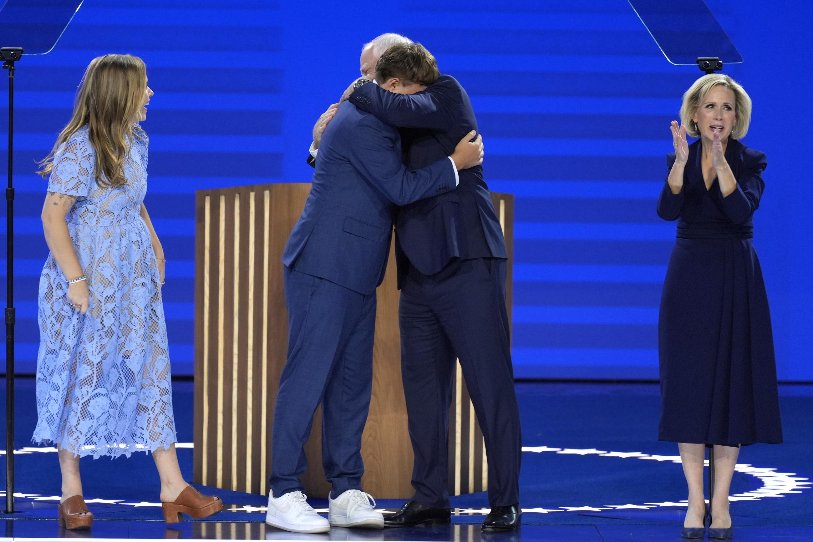Minnesota Gov. Tim Walz hugs his son, Gus, as his wife, Gwen (right), and daughter, Hope (left), look on at the Democratic National Convention on Wednesday. (AP Photo/J. Scott Applewhite)