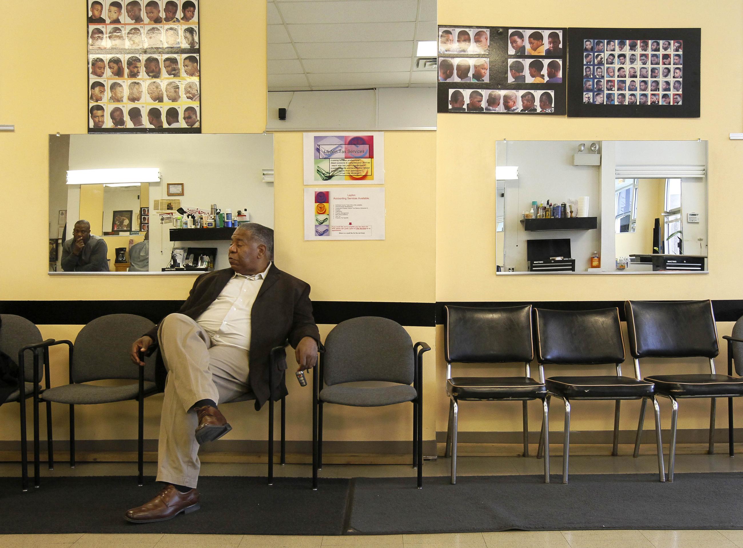Charles Leeks sits and talks about former President Obama's first term and the election with barber Bert Downing at Carter's Barbershop on Election Day Tuesday, Nov. 6, 2012, in Chicago. (AP Photo/Charles Rex Arbogast)