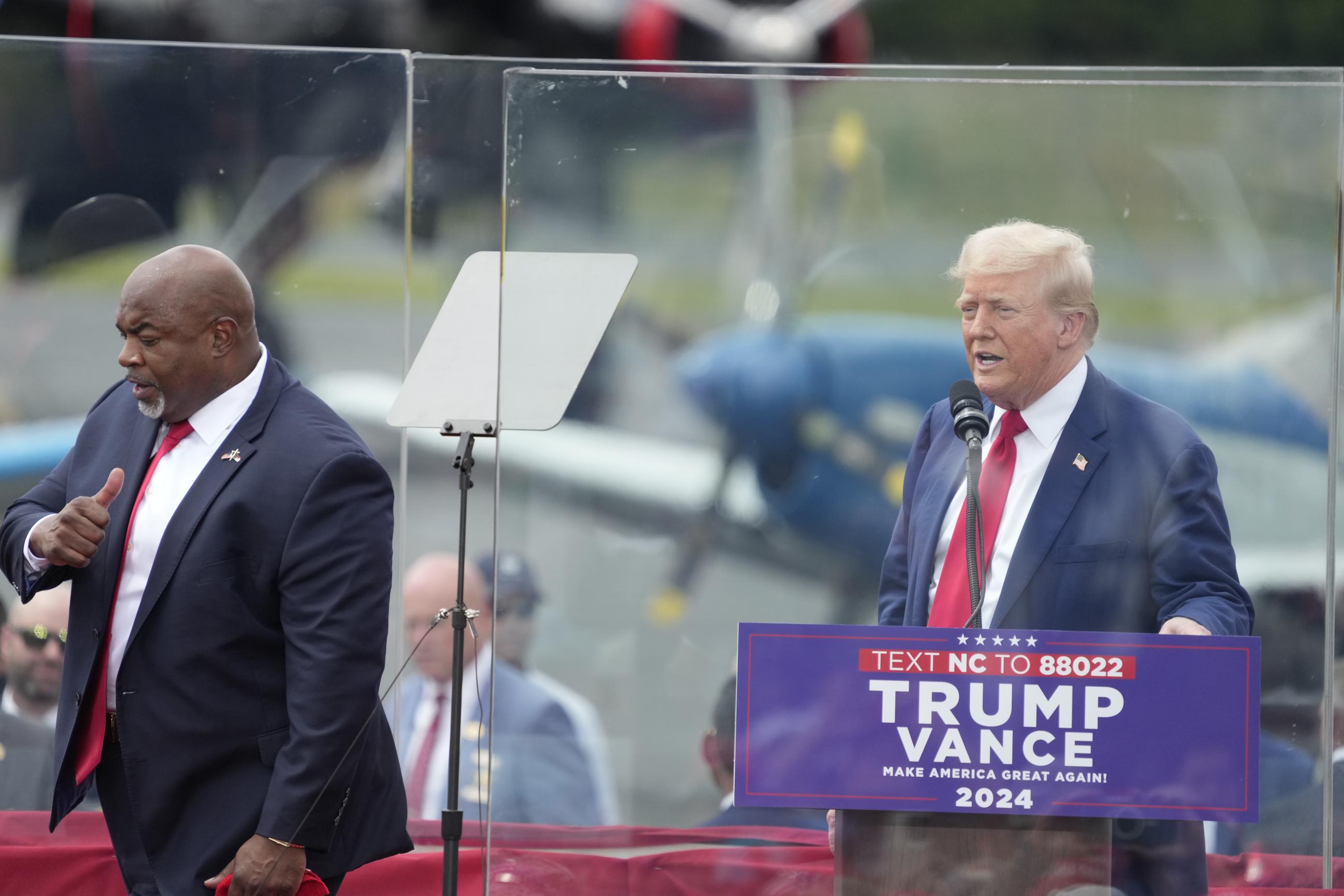 North Carolina Lt. Gov. Mark Robinson, left, walks past former President Donald Trump, right, after being introduced at a Trump campaign event in Asheboro, N.C., Wednesday, Aug. 21, 2024. Robinson is the Republican candidate for N.C. governor. (AP Photo/Chuck Burton)
