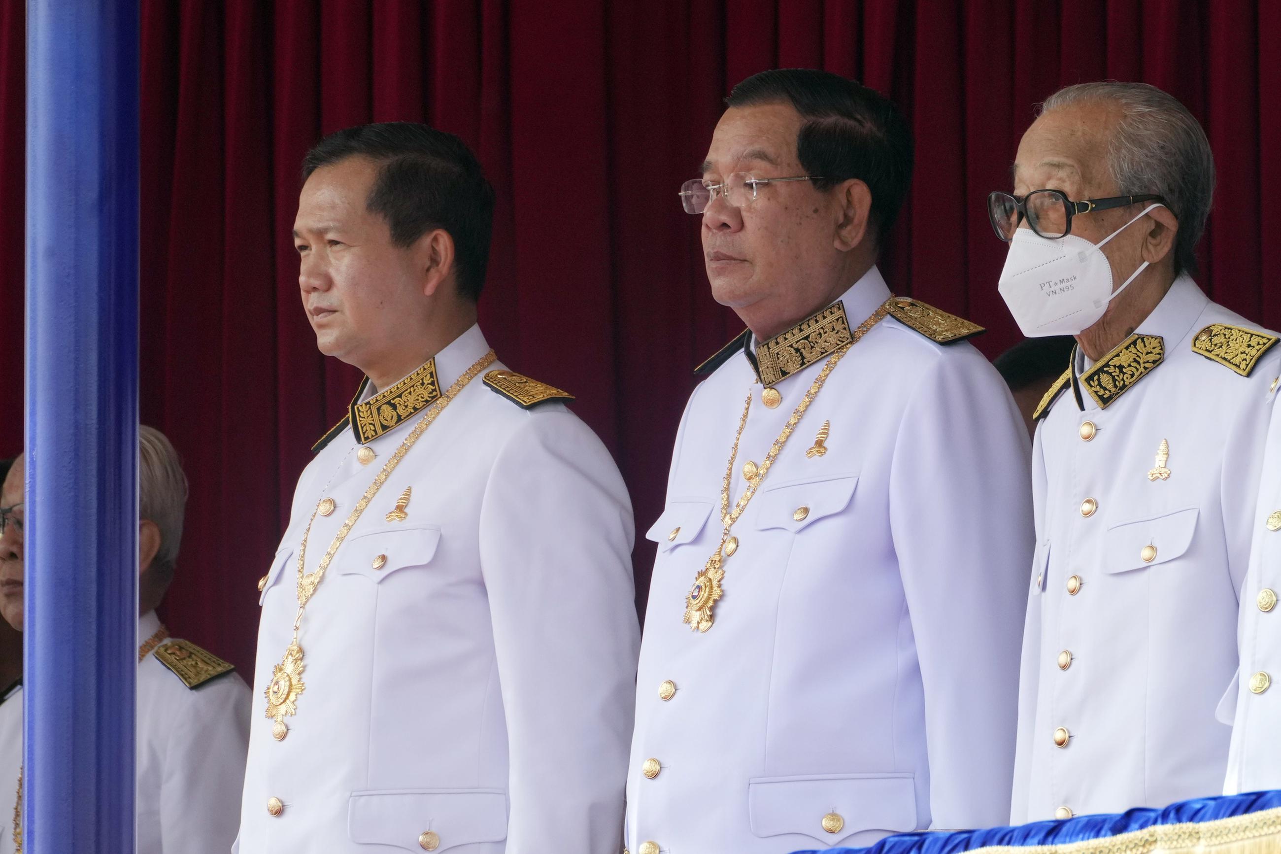 Cambodian Prime Minister Hun Manet, centre left, stands next to his father and former prime minister Hun Sen, center right, during the country's 70th Independence Day, in Phnom Penh, Cambodia, Thursday, Nov. 9, 2023. (AP Photo/Heng Sinith)