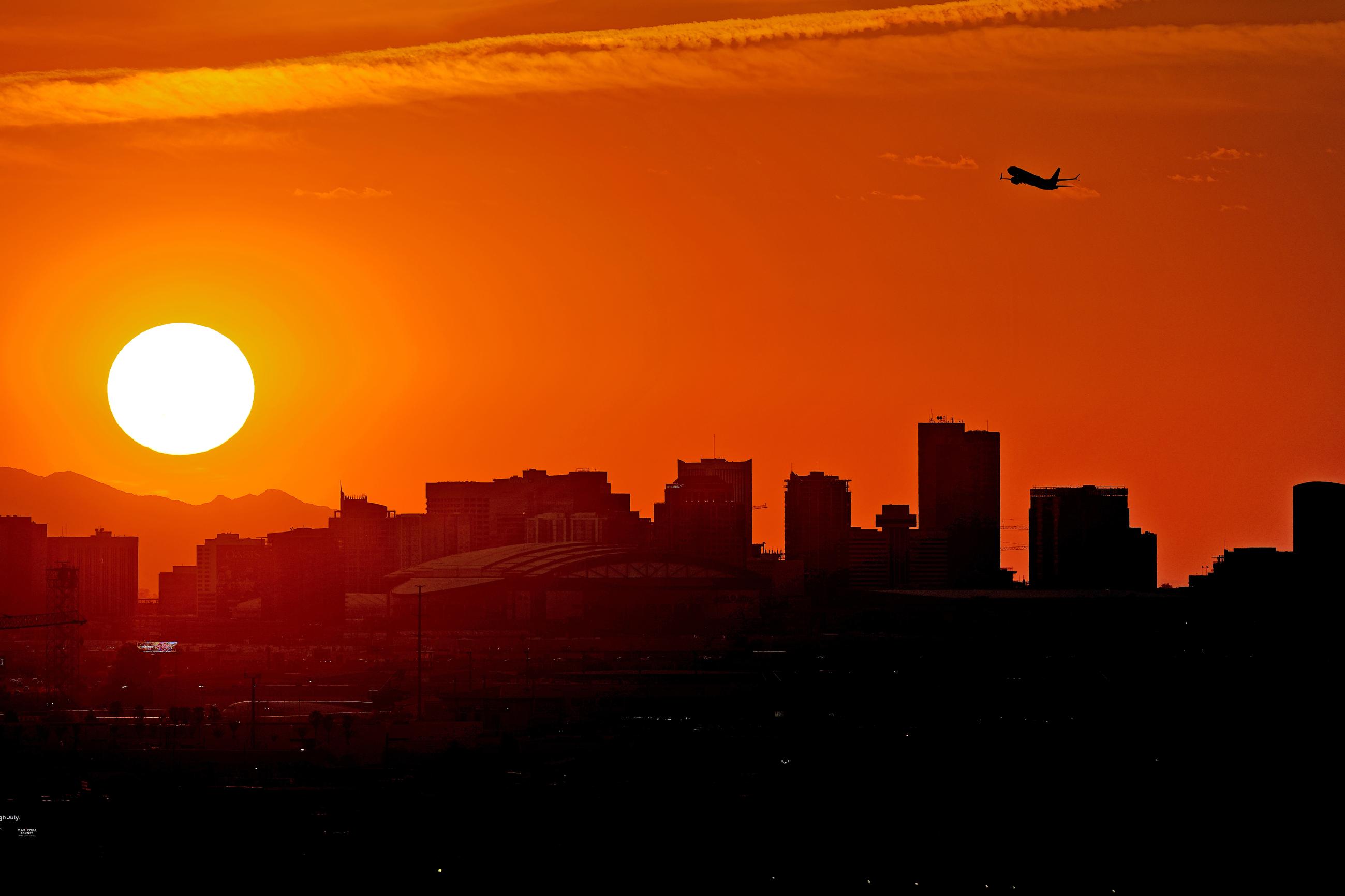A jet takes flight from Sky Harbor International Airport as the sun sets over Phoenix. (AP Photo/Matt York, File)