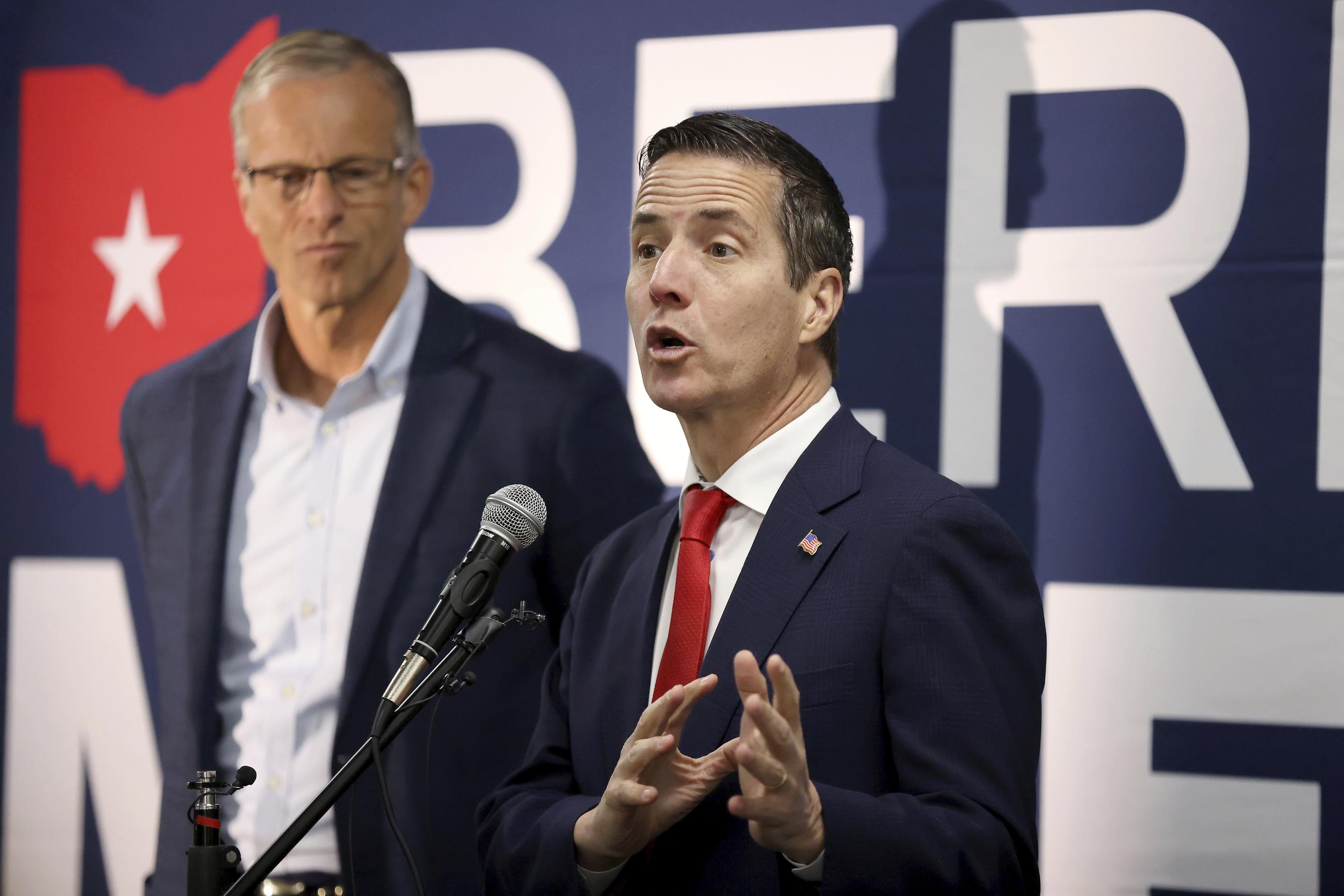 Bernie Moreno, Republican senatorial candidate for Ohio, right, speaks during a bus tour stop for the Ohio Senate race, as Senator John Thune of South Dakota looks on, in Columbus, Ohio, Monday, Oct. 28, 2024. (AP Photo/Joe Maiorana)