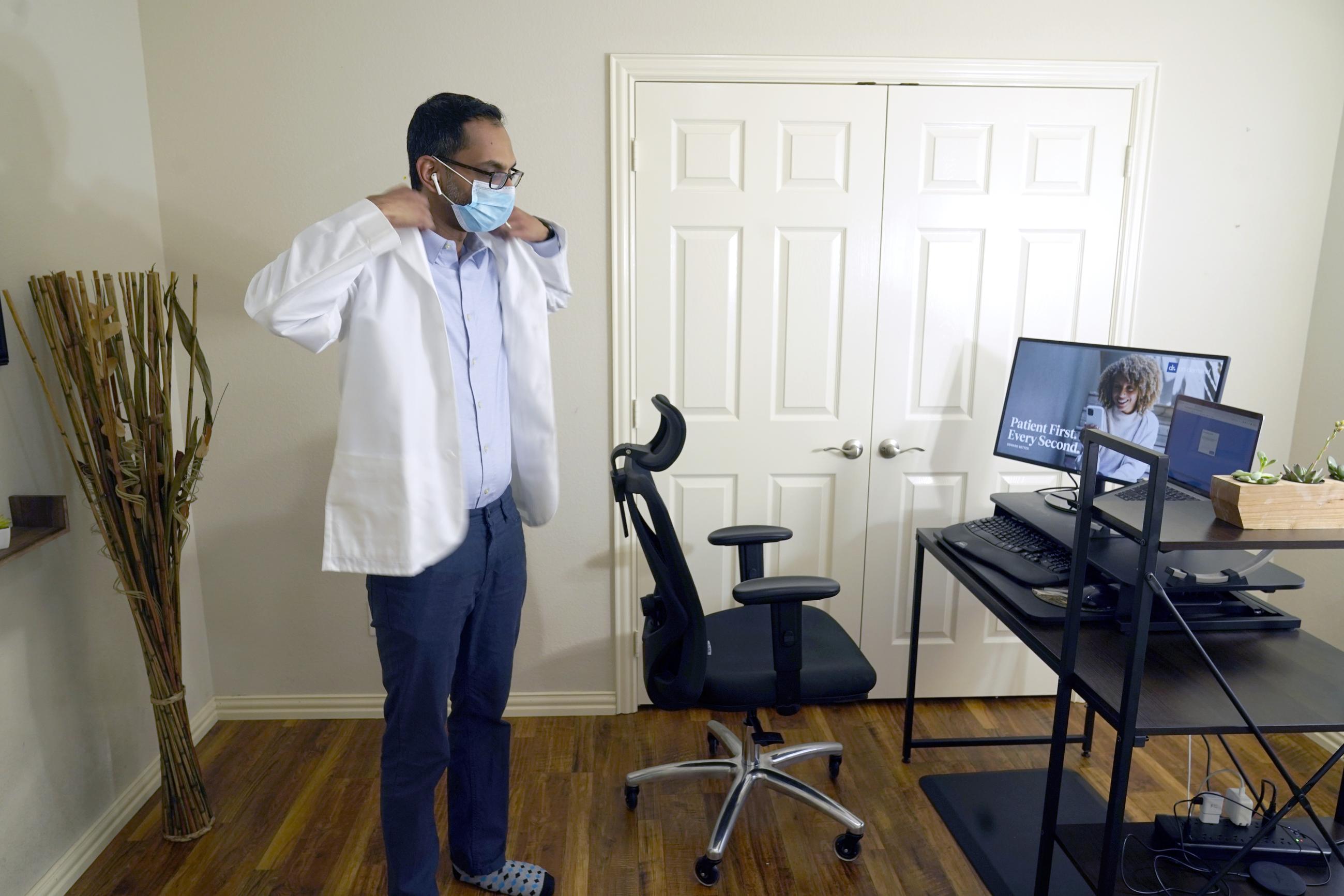 A doctor prepares to conduct an online visit with a patient from his work station at home in 2021. (AP Photo/LM Otero, File)