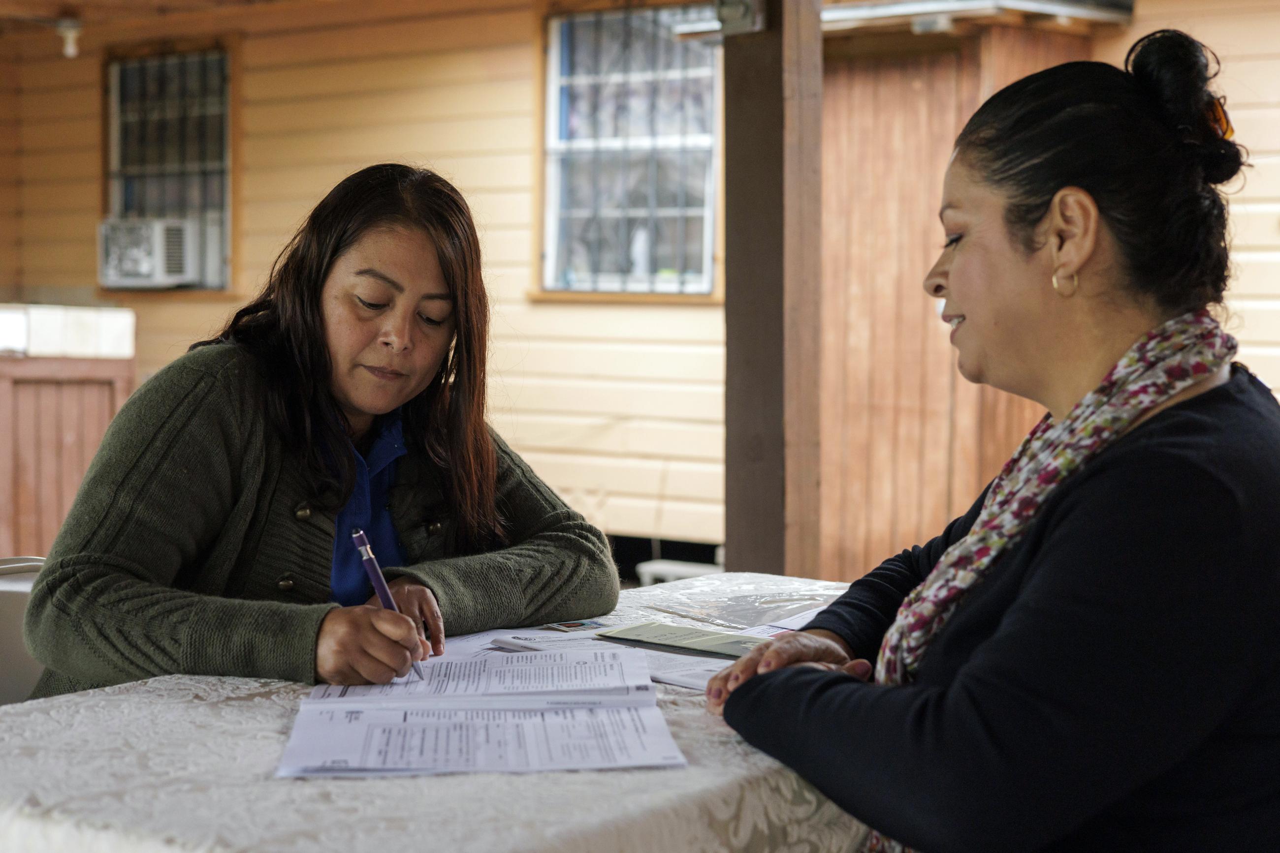 Children's Defense Fund program director Graciela Camarena assists Lucia Salazar with filling out Medicaid and SNAP application forms for her family in Pharr, Texas, Monday, Nov. 13, 2023. As the state reviews Texans' eligibility, some 1 million people have already lost Medicaid and organizations like the one Graciela works for assist people in applying again. (AP Photo/Michael Gonzalez
