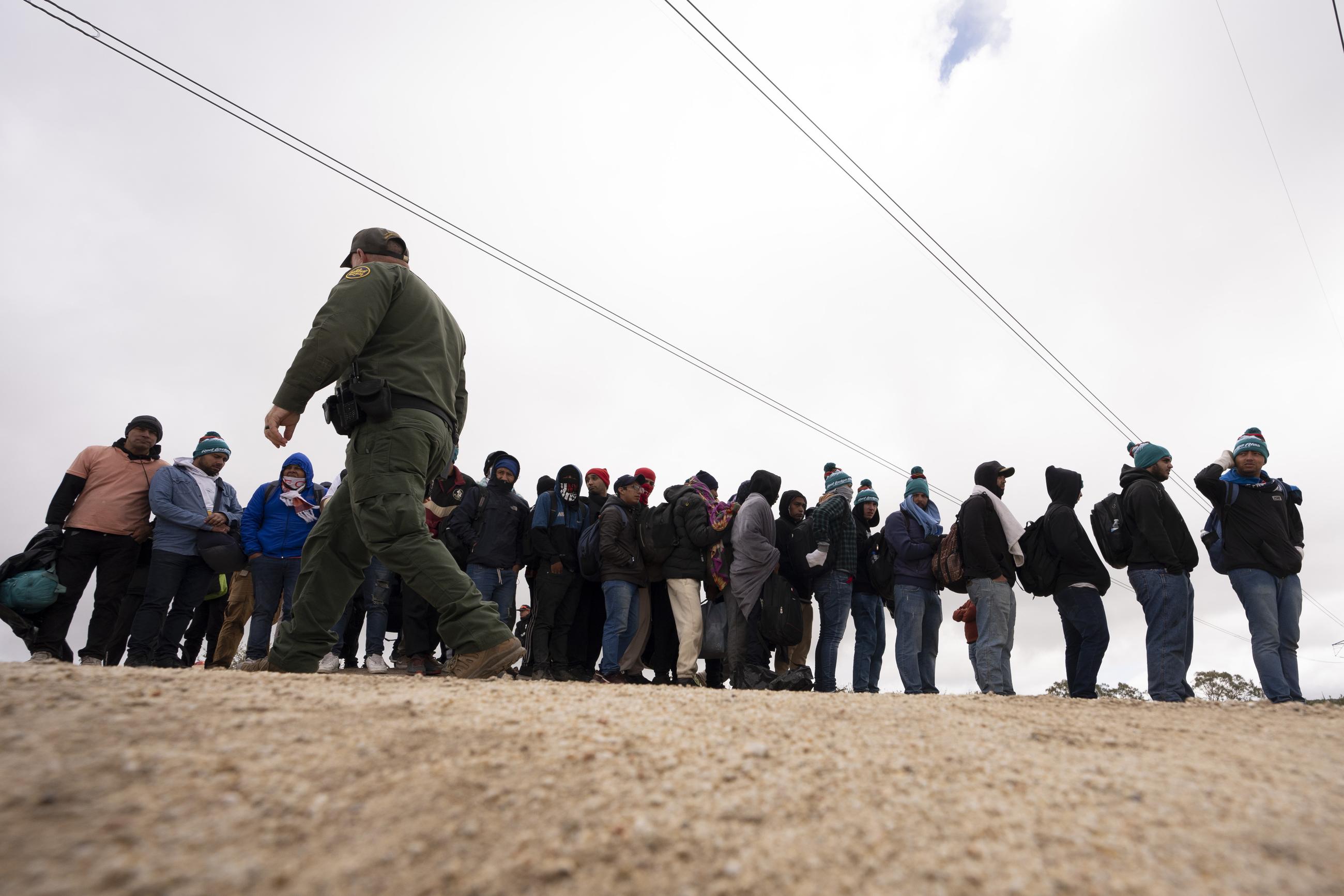Men seeking asylum line up as they wait to be processed after crossing the border with Mexico in April 2024 in Boulevard, Calif. (AP Photo/Gregory Bull, File)