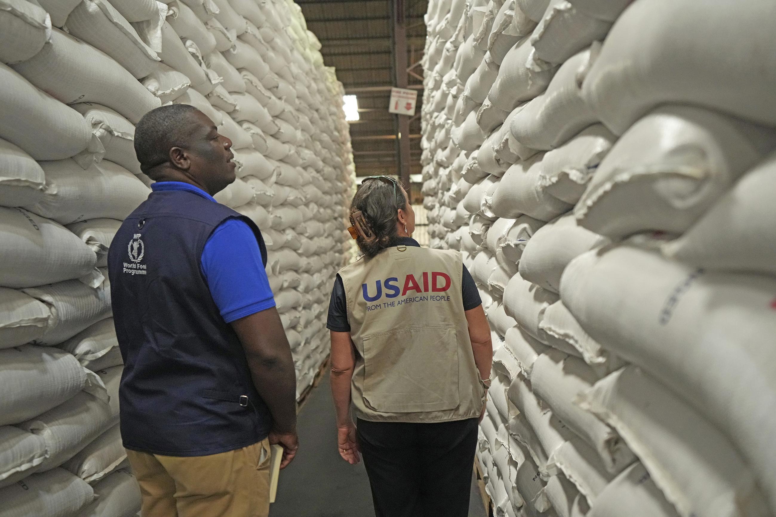 Officials from USAID and WFP inspect a donation of $11 million worth of food aid at a ceremony in Harare, Zimbabwe, earlier this month. (AP Photo/Tsvangirayi Mukwazhi)