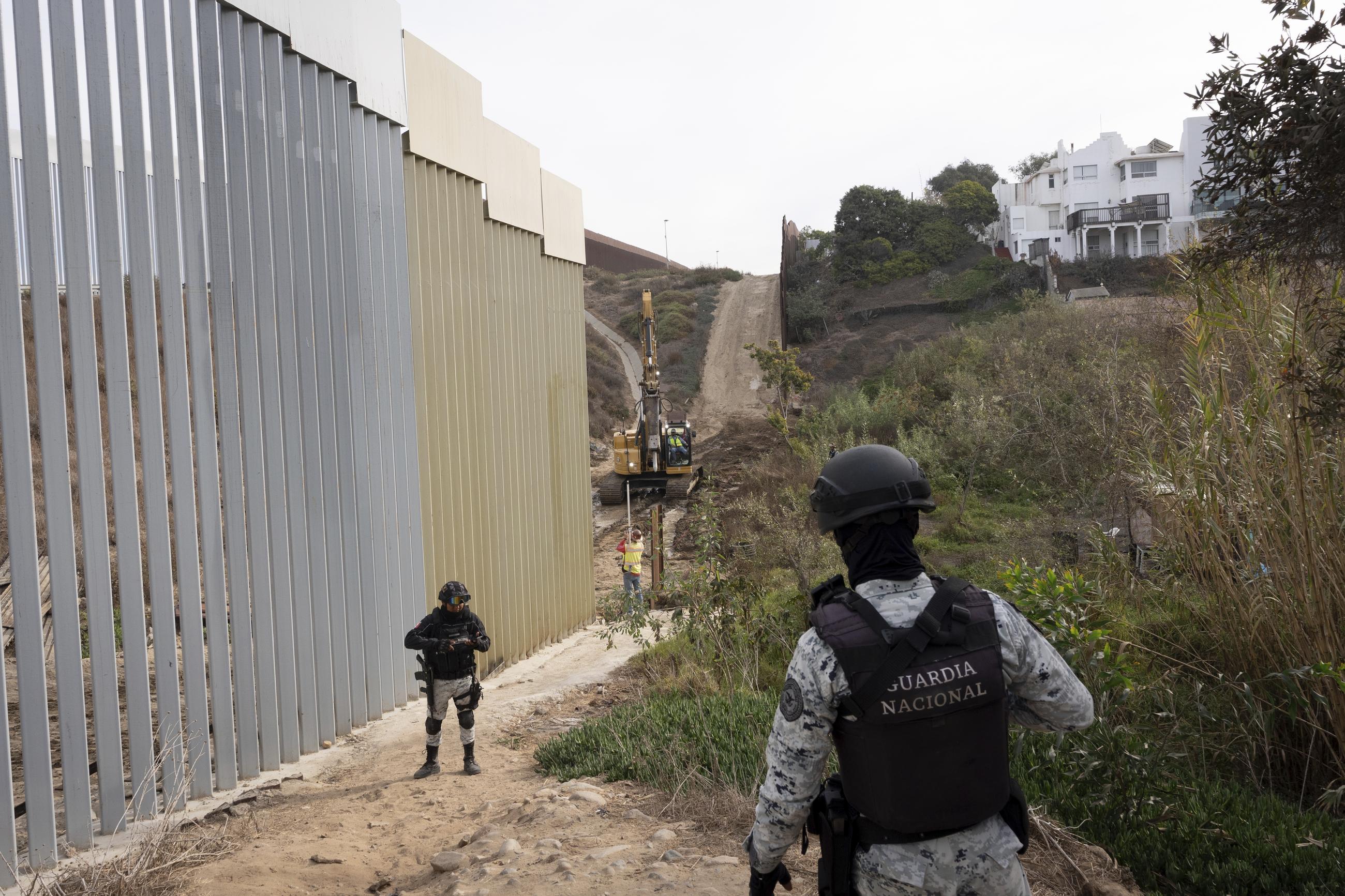 Members of the Mexican National Guard patrol as construction crews replace sections of one of two border walls separating Mexico from the United States Wednesday in Tijuana, Mexico. (AP Photo/Gregory Bull)