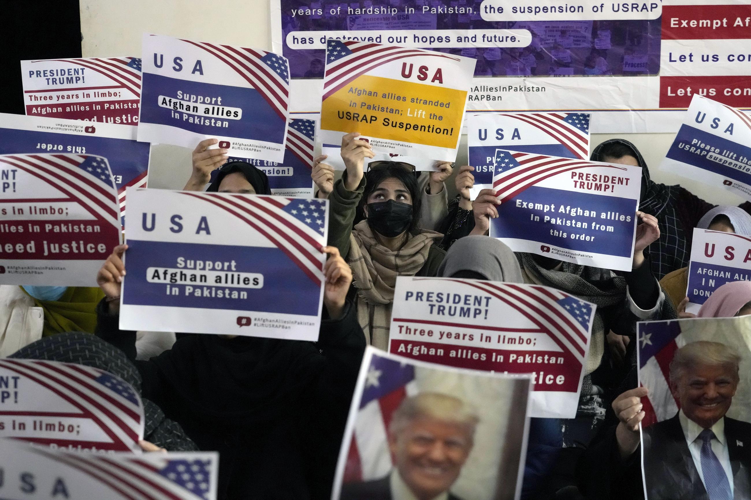 Afghan refugees in Islamabad, Pakistan, on Friday hold placards in response to President Trump's pause of the U.S. refugee program. (AP Photo/Anjum Naveed)