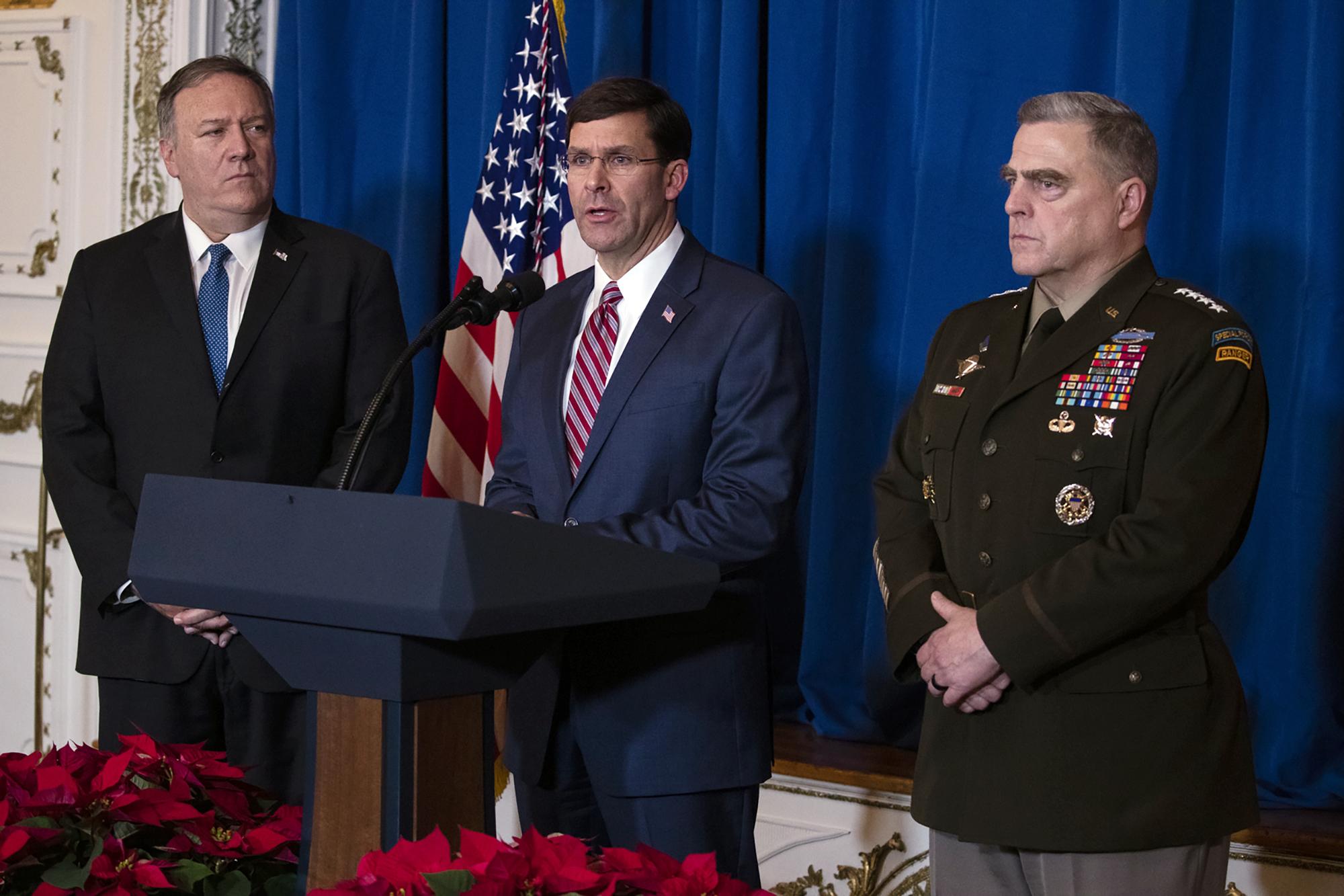 Former Defense Secretary Mark Esper (at the podium) and Gen. Mark Milley (right), shown in 2019, are among the targets of President Trump's efforts at retribution for perceived past wrongs. (AP Photo/ Evan Vucci)