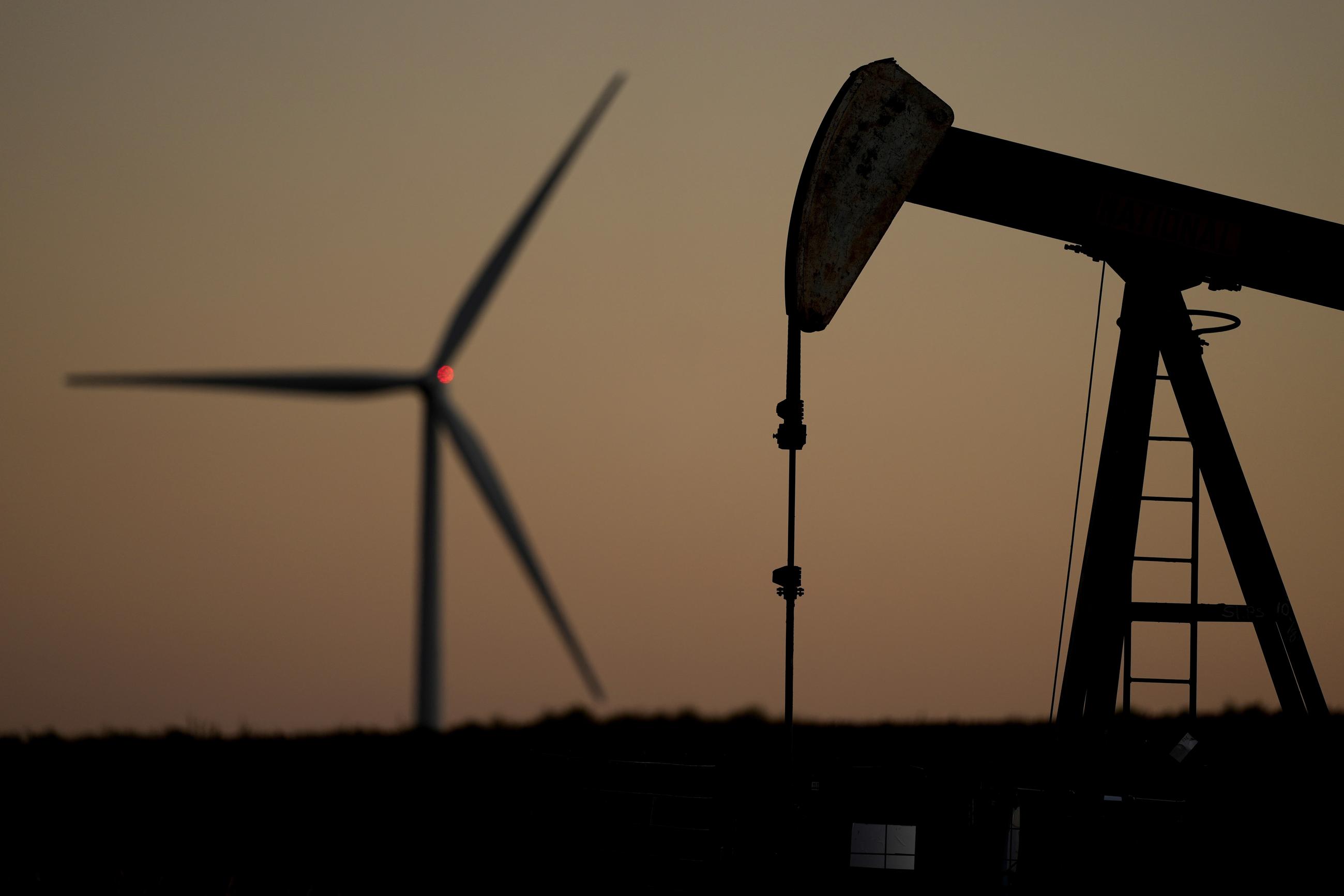 A pumpjack and a wind turbine near Hays, Kansas (AP Photo/Charlie Riedel, File)
