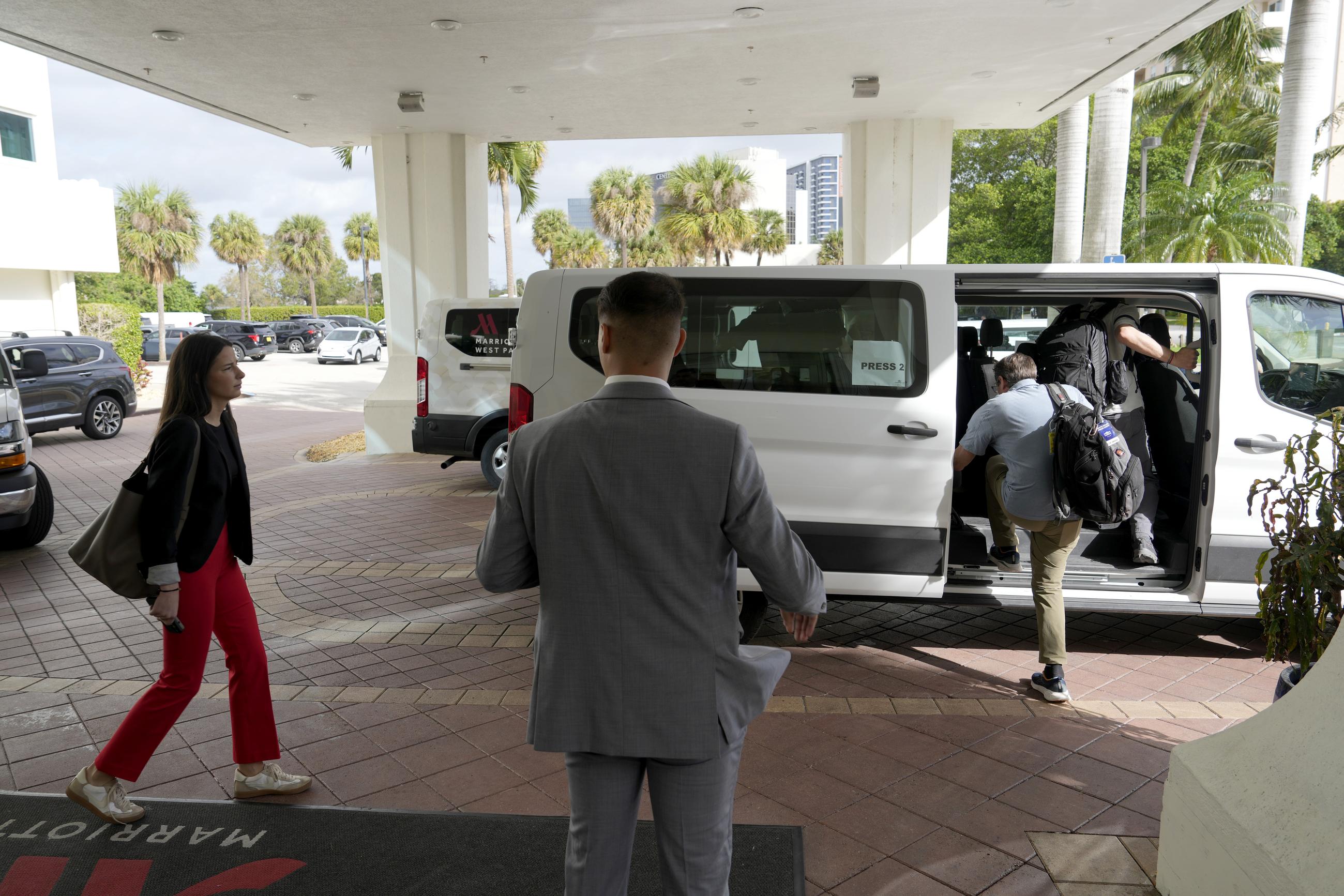 White House press assistant Olivia Wales (left) walks as members of the White House traveling press pool board a van in West Palm Beach, Fla., on Feb. 16. (AP Photo/Ben Curtis)