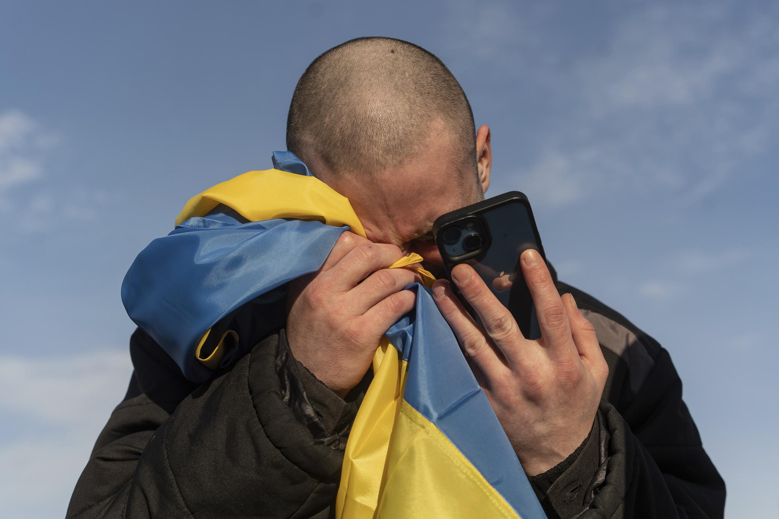 A recently swapped Ukrainian prisoner of war cries while calling his relatives after a prisoner exchange on the Ukrainian-Russian border in January 2024. (AP Photo/Danylo Pavlov, File)