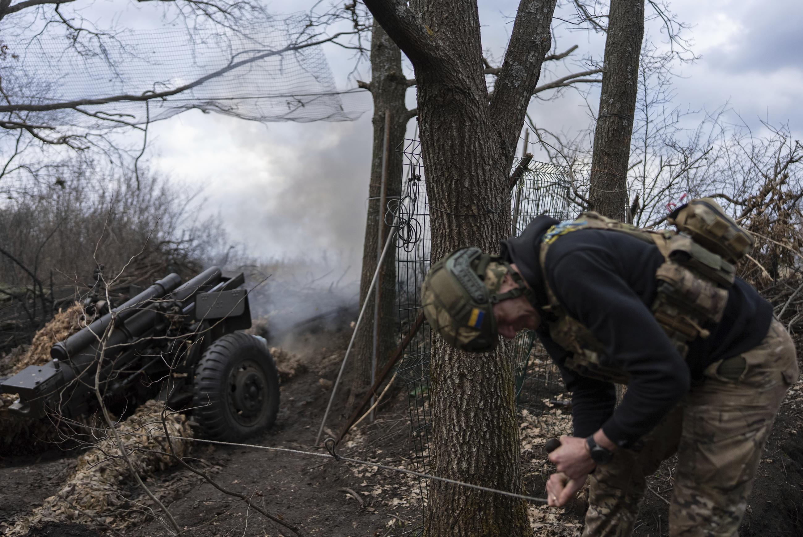 Ukrainian serviceman of Khartia brigade known by call sign "Krystal" fires M101 Howitzer towards Russian positions in Kharkiv region, Ukraine on Wednesday. (AP Photo/Alex Babenko)