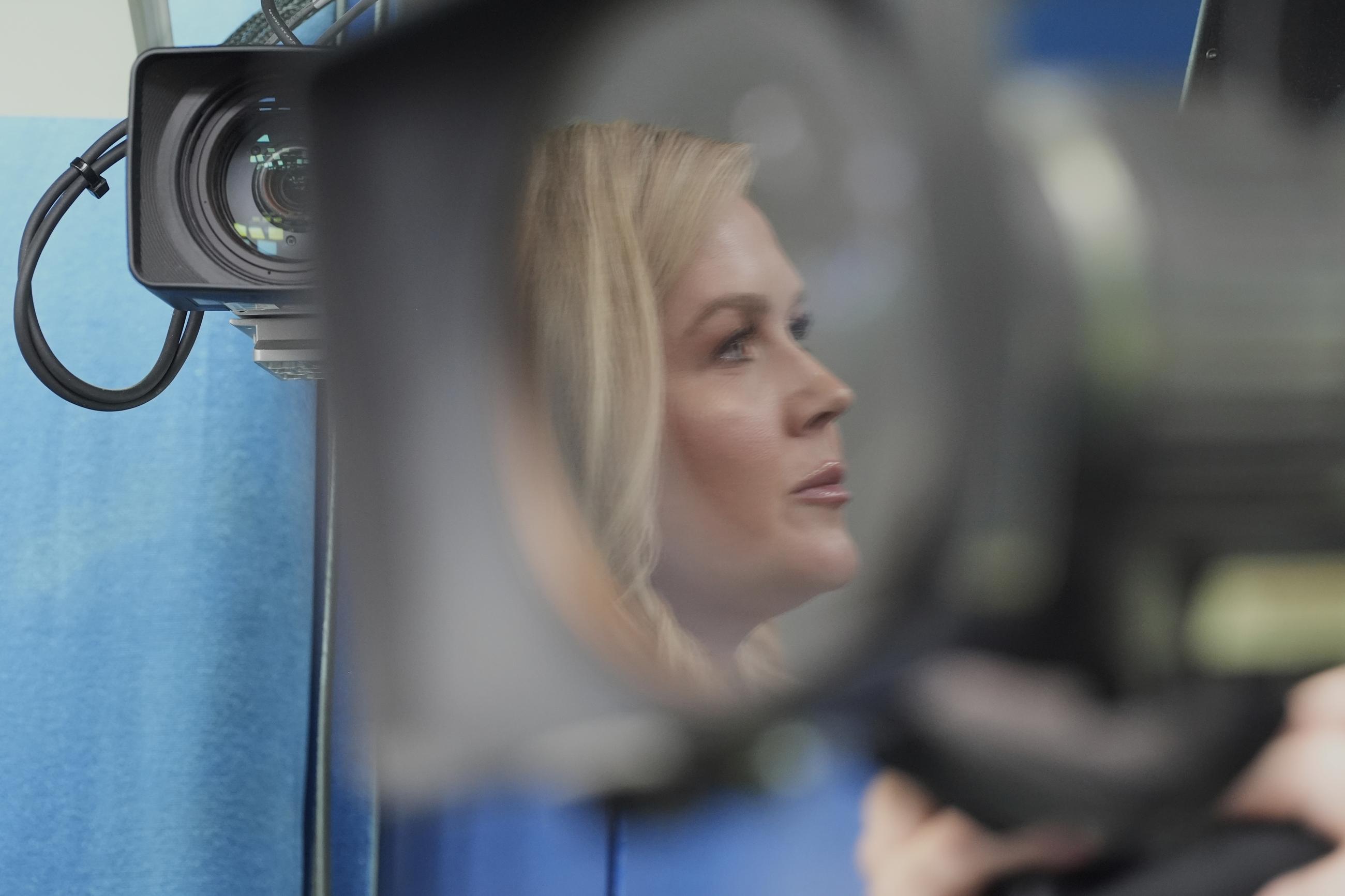 White House press secretary Karoline Leavitt, reflected in a camera lens, speaks with reporters in the James Brady Press Briefing Room at the White House, Tuesday, March 11, 2025, in Washington. (AP Photo/Alex Brandon)