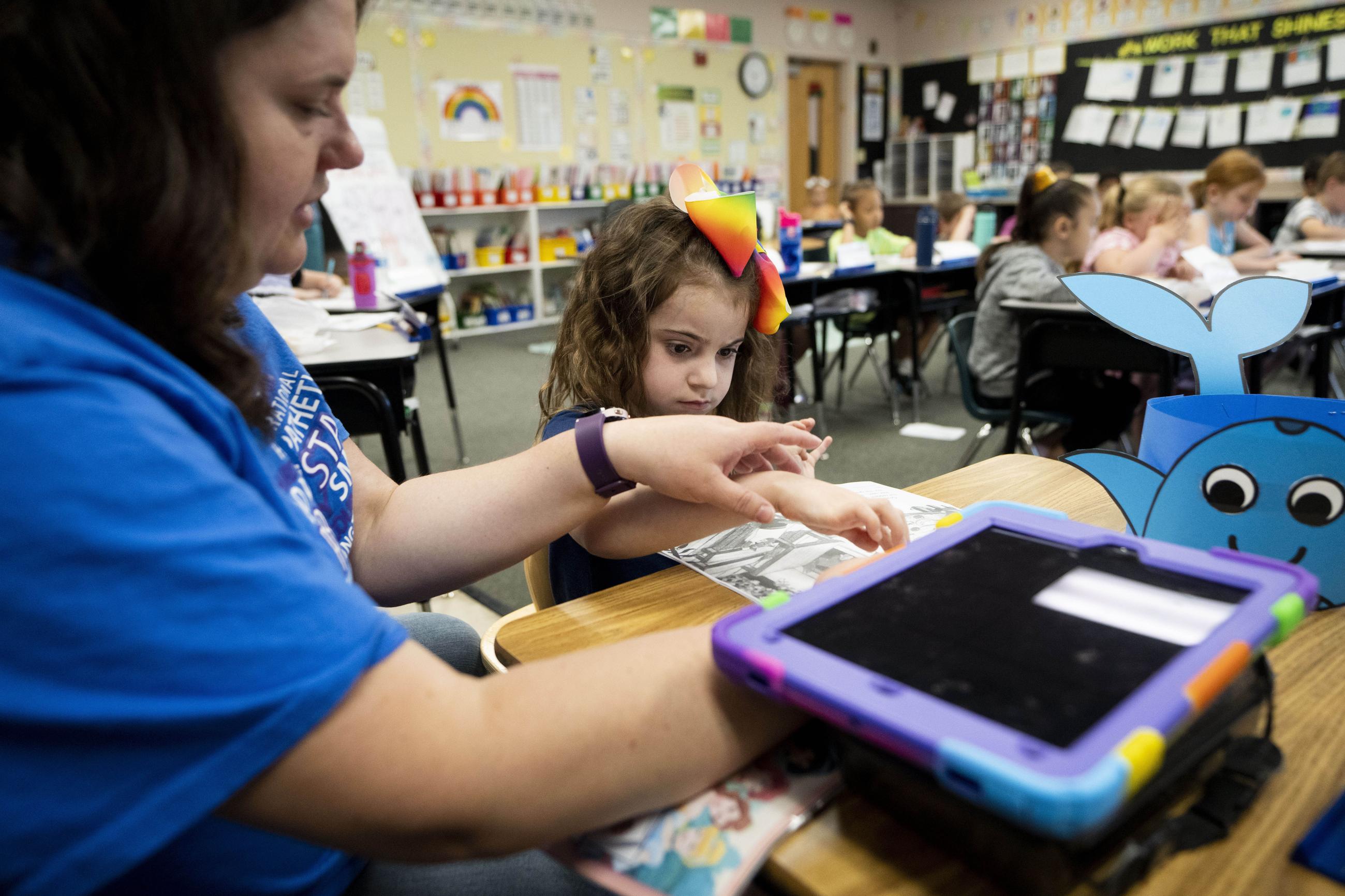 A long-term substitute special-education teacher works with a student. (AP Photo/Lindsey Wasson)