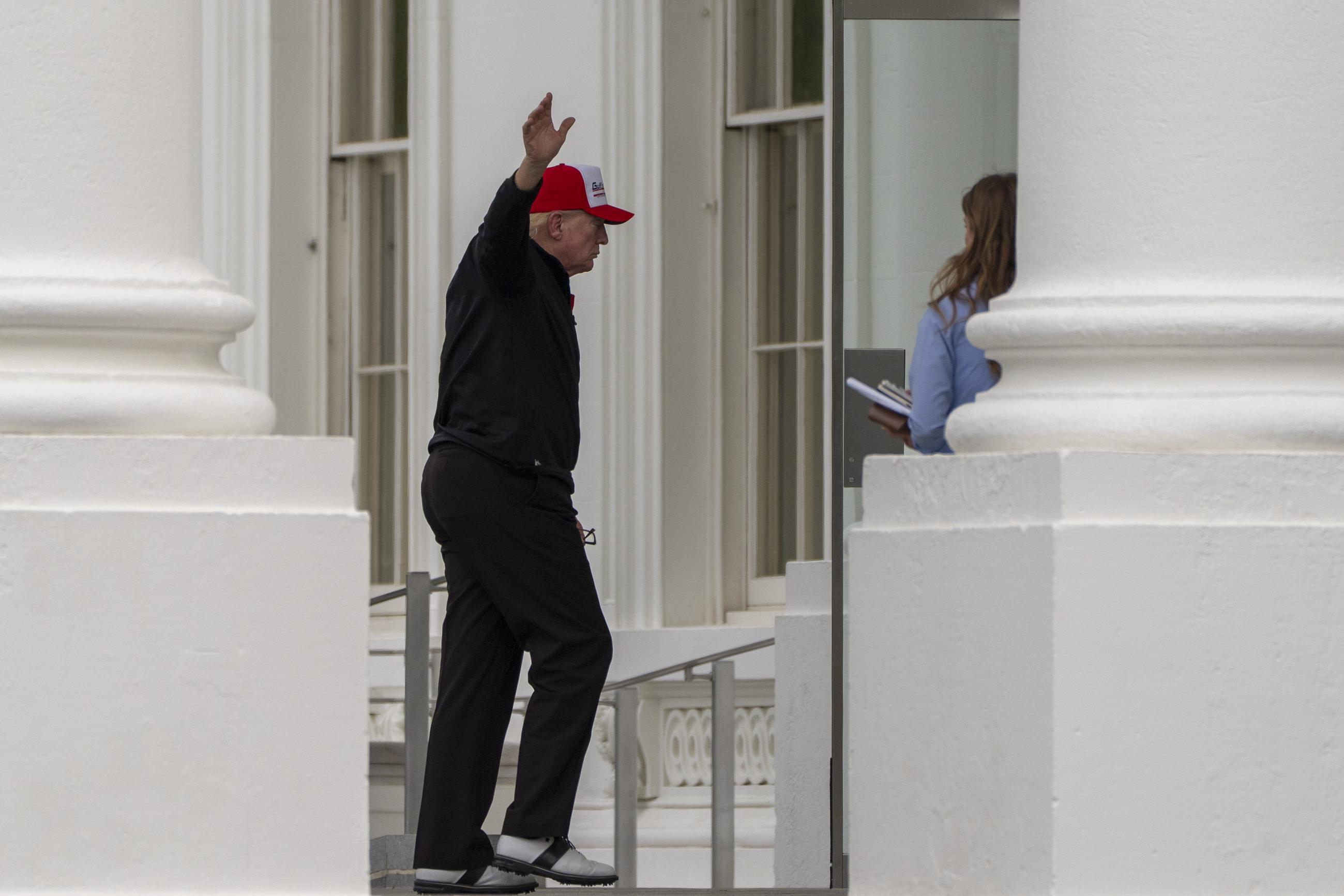 President Trump waves as he returns to the White House on Sunday. (AP Photo/Alex Brandon)