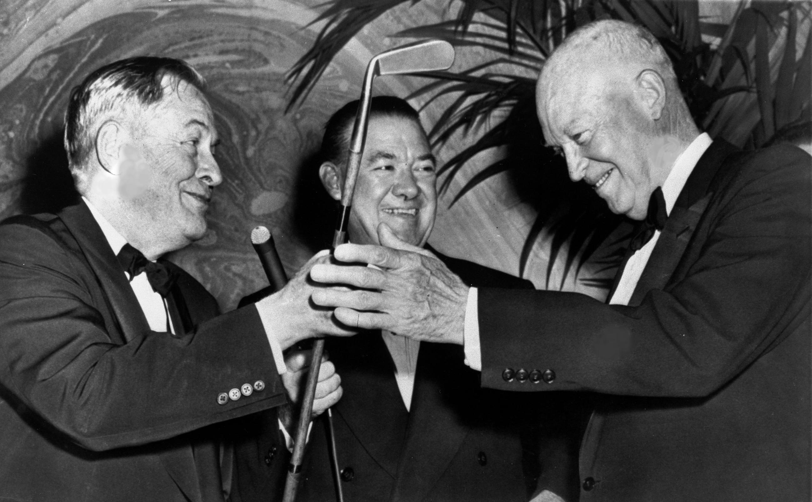 American golfer Bobby Jones (left) presents a duplicate of his famous putter, "Calamity Jane," to President Dwight D. Eisenhower at the White House Correspondents' Association Dinner in 1959. In the center is reporter Felix Belair Jr. (AP Photo)