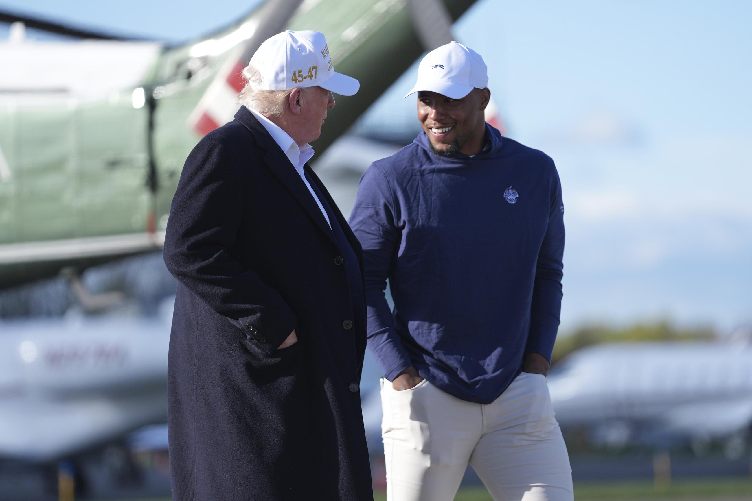 President Trump walks with Philadelphia Eagles football player Saquon Barkley before boarding Air Force One in Morristown, N.J., on Sunday. (AP Photo/Evan Vucci)