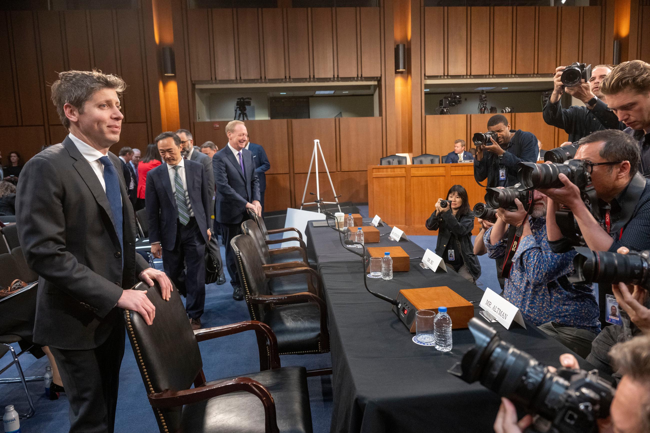 Sam Altman, co-founder and Chief Executive Officer, OpenAI, left, stands in front of photographers before the start of a Senate Committee on Commerce, Science, and Transportation hearing, Thursday, May 8, 2025 in Washington. (AP Photo/Kevin Wolf)