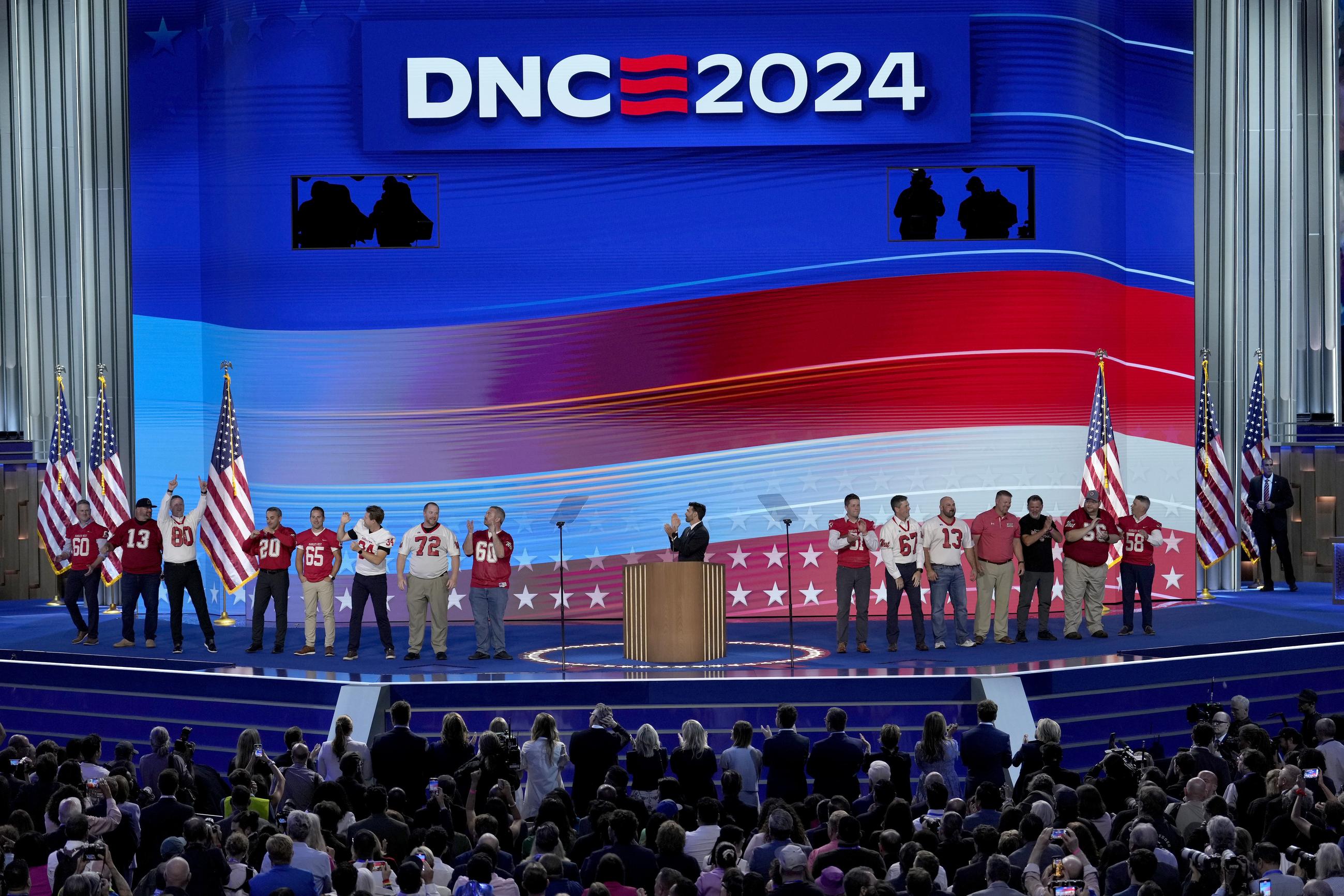 Benjamin C. Ingman, center, former student of Democratic vice presidential candidate Minnesota Gov. Tim Walz, is joined on stage by former members of the Mankato West High School football team during the Democratic National Convention Wednesday, Aug. 21, 2024, in Chicago. (AP Photo/J. Scott Applewhite)