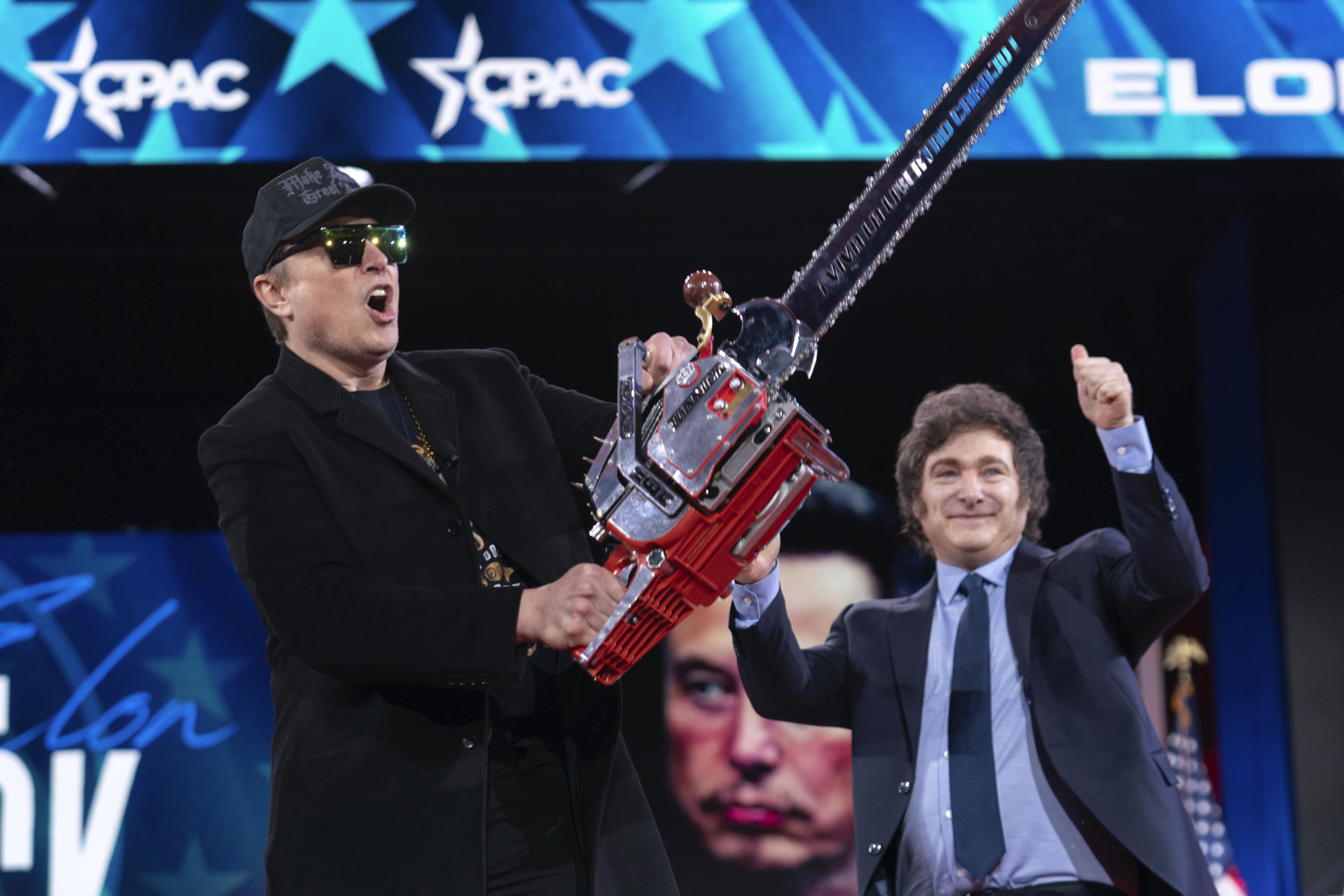 Elon Musk (left) receives a chainsaw from Argentina's President Javier Milei at the Conservative Political Action Conference in Oxon Hill, Md., in February. (AP Photo/Jose Luis Magana)