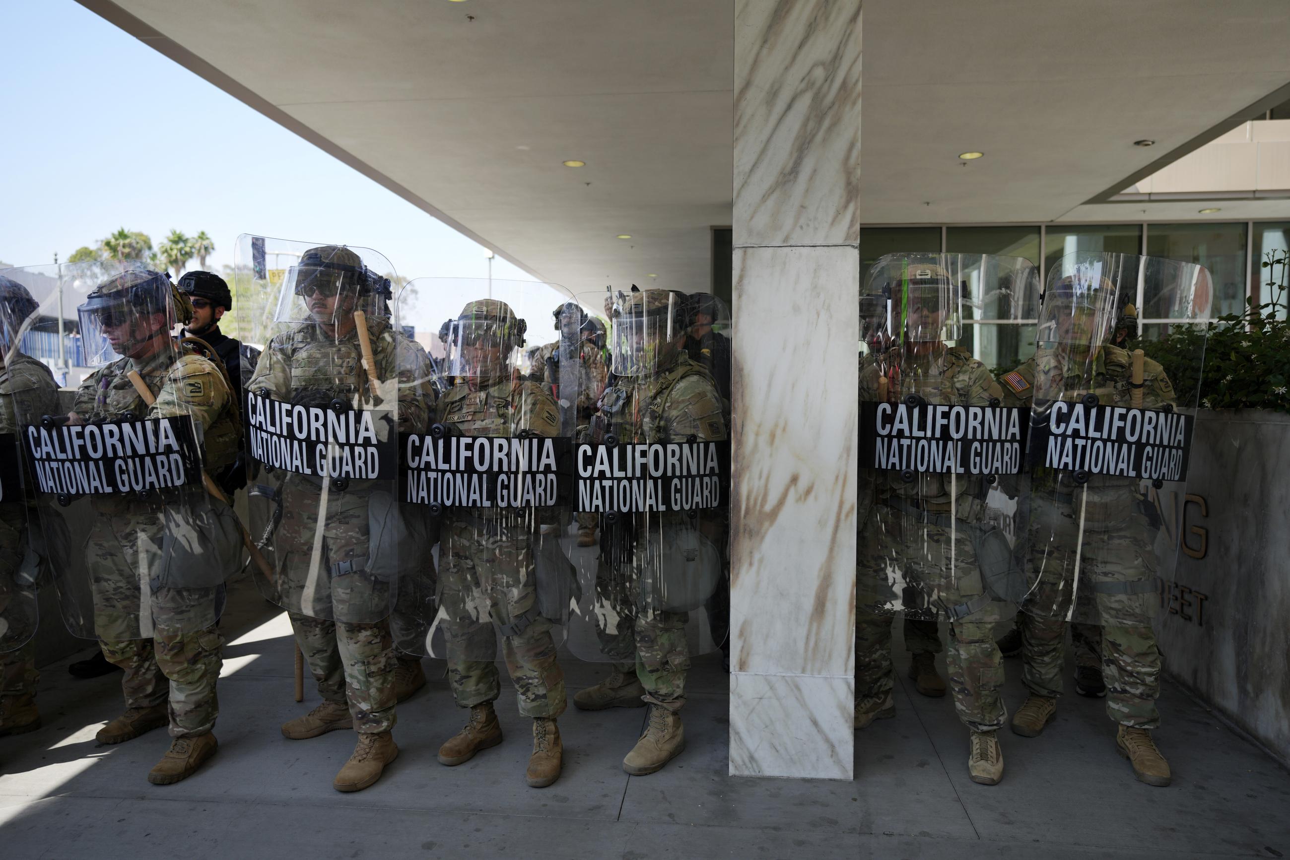 A line of California National Guard troops stand in formation guarding a federal building in downtown Los Angeles on Monday. (AP Photo Jae Hong)