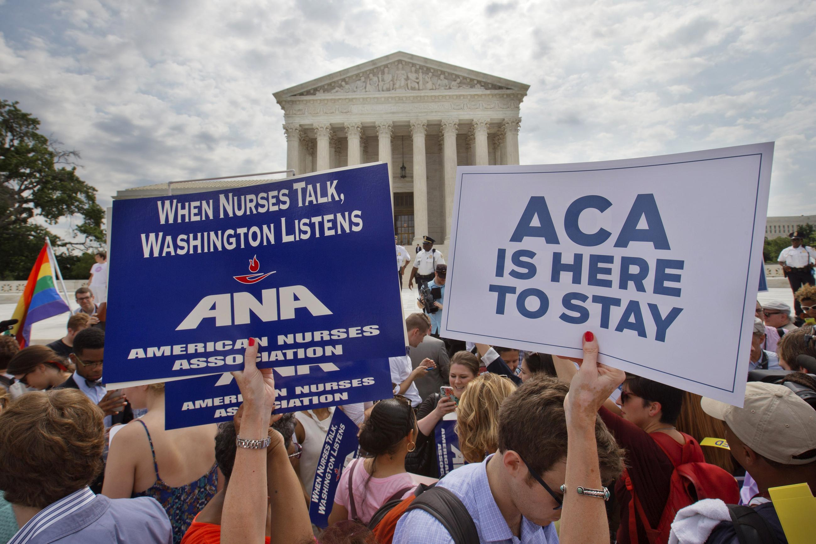 FILE - Supporters of the Affordable Care Act hold up signs outside the Supreme Court in 2015, when the Court upheld the nationwide tax subsidies under the ACA.