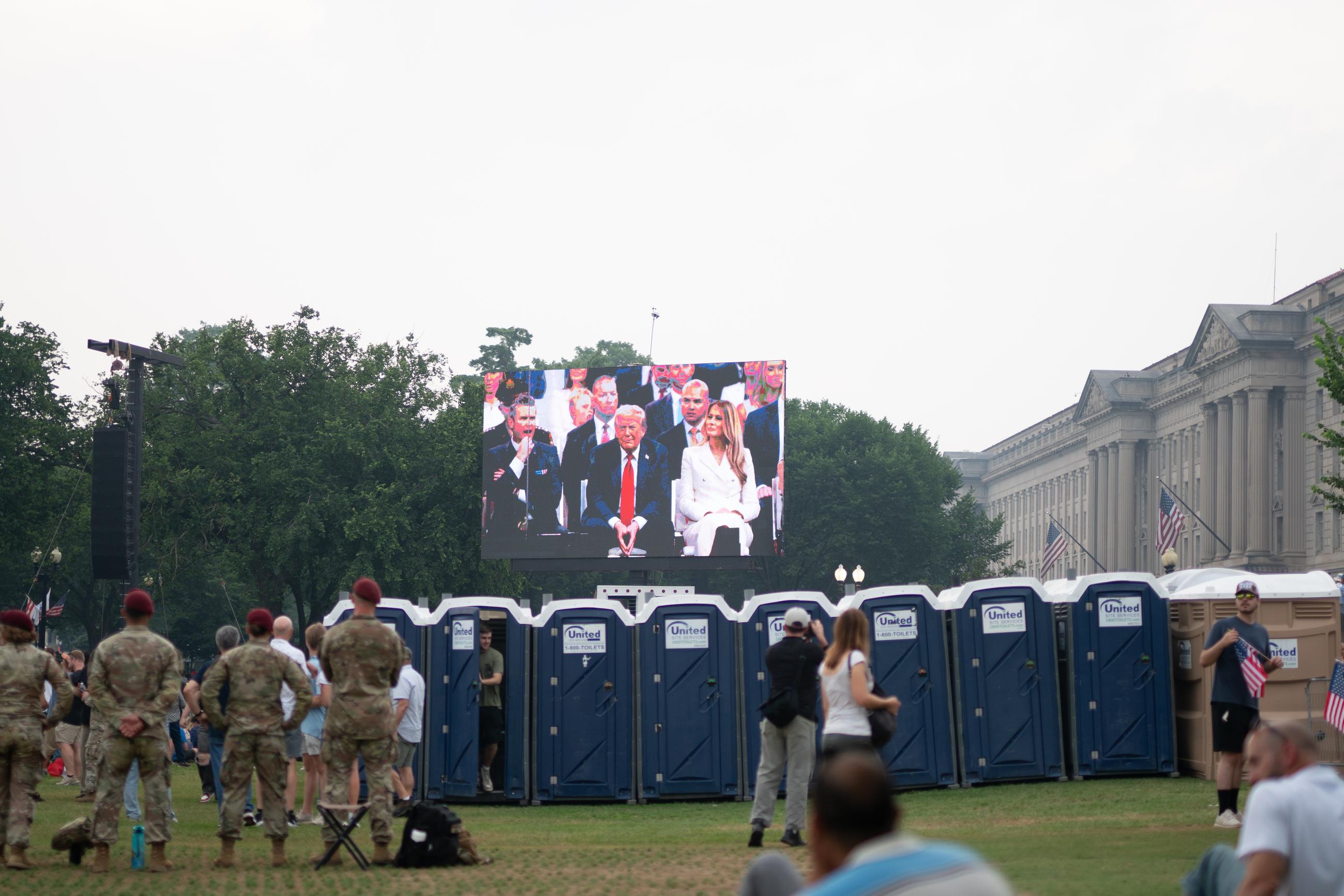 Members of the U.S. Airborne Brigade watch as President Trump appears on the screen from the military parade podium. June 15, 2025.