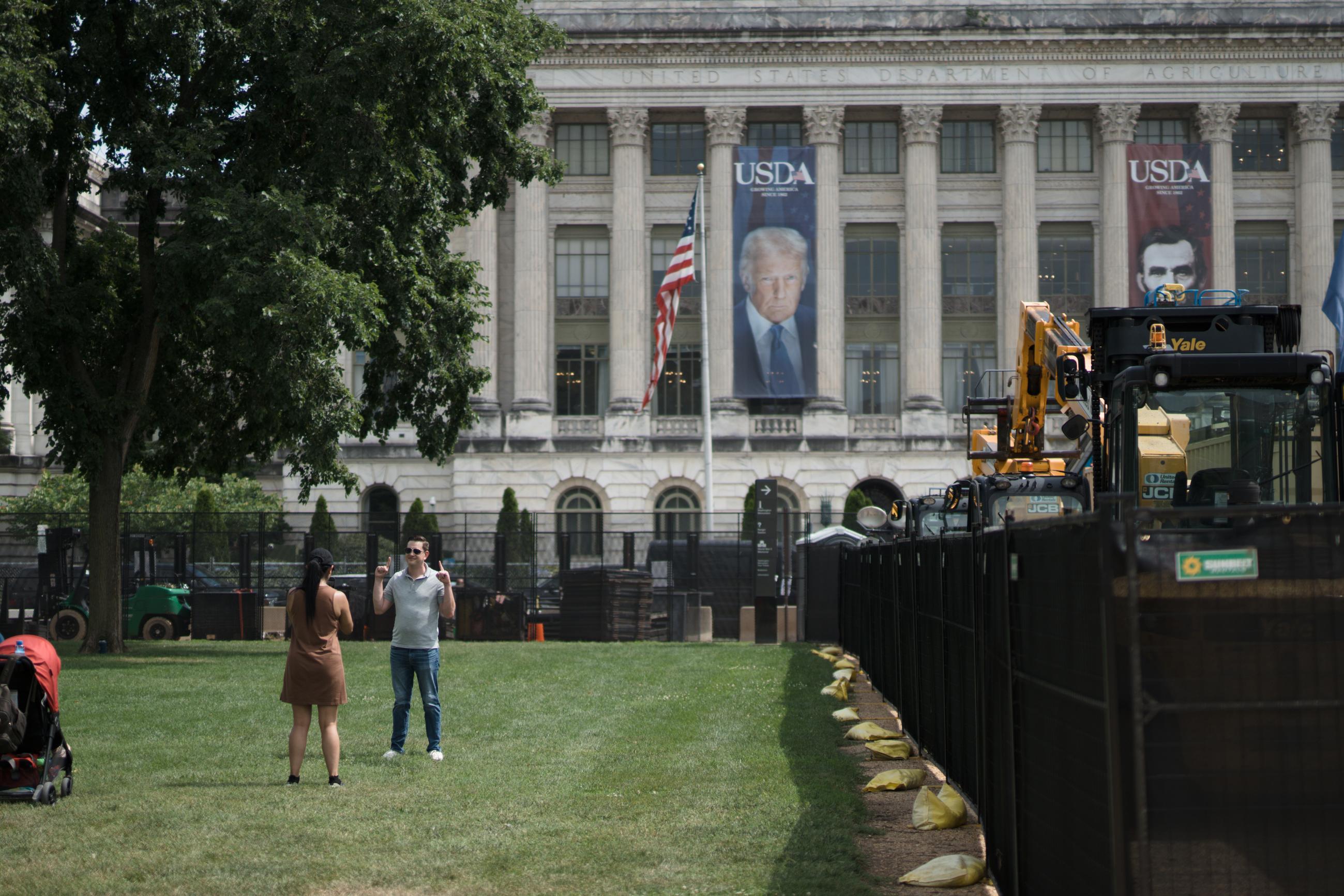 Damon Bronstetter has his photo taken nearby President Trump’s &amp; former President Lincoln's USDA banners during the Army's 250th birthday festivities. June 15, 2025