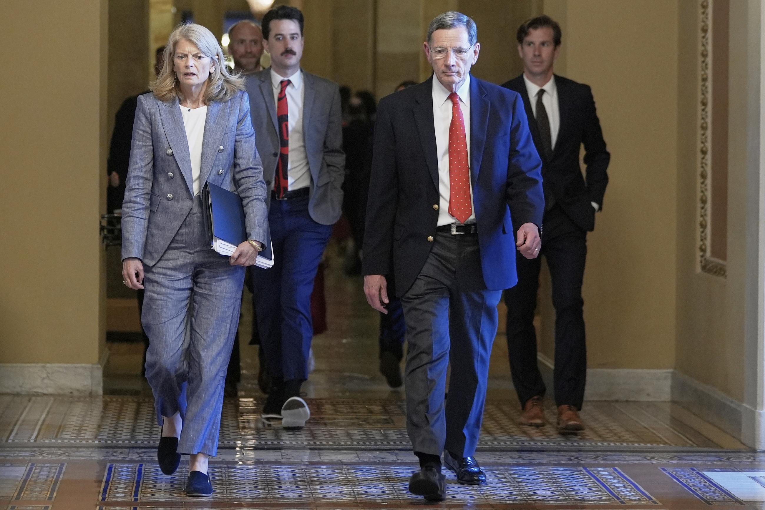 Sen. Lisa Murkowski, R-Alaska, left, and Sen. John Barrasso, R-Wyo., right, walk at the Capitol, Tuesday, July 1, 2025, in Washington. (AP Photo/Mariam Zuhaib)