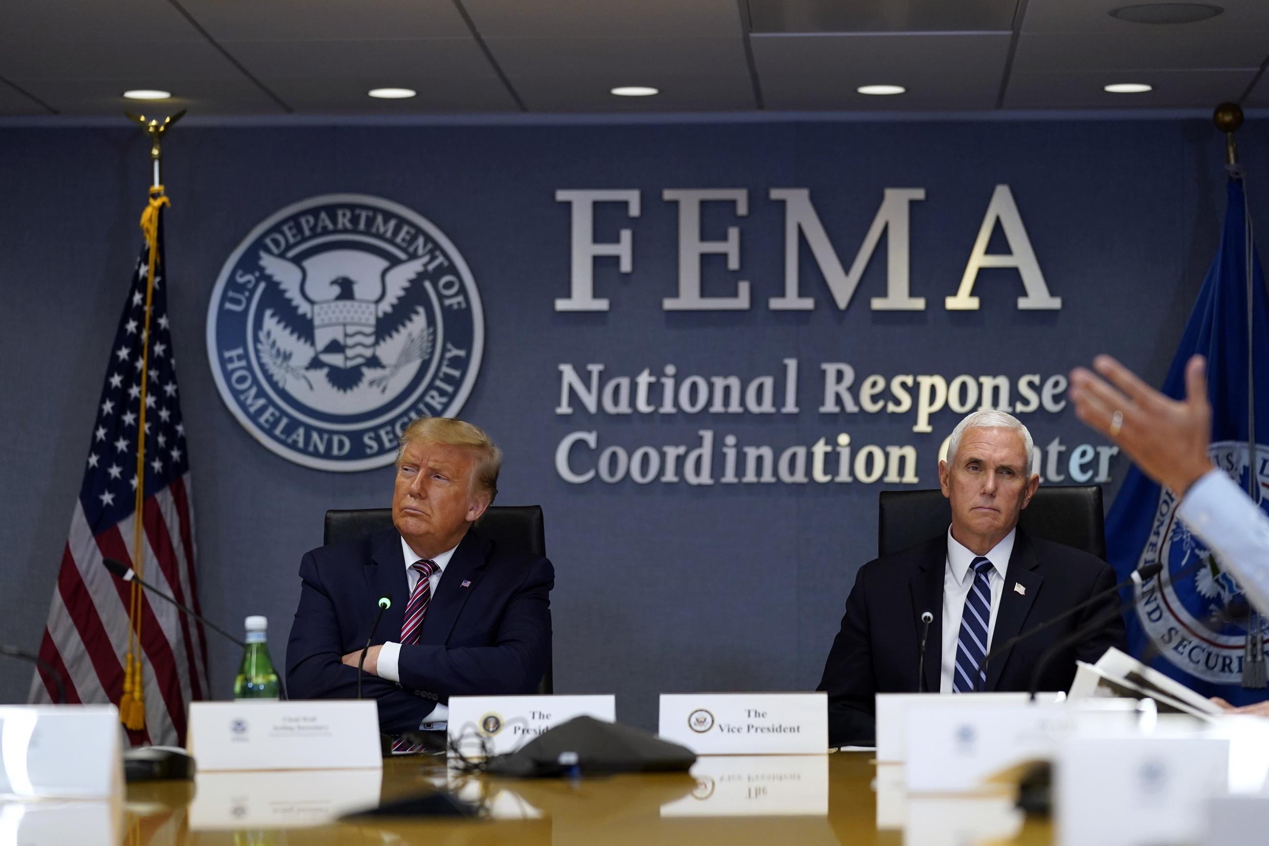 President Donald Trump and Vice President Mike Pence listen during a Hurricane Laura briefing at FEMA headquarters, Thursday, Aug. 27, 2020, in Washington. (AP Photo/Evan Vucci)