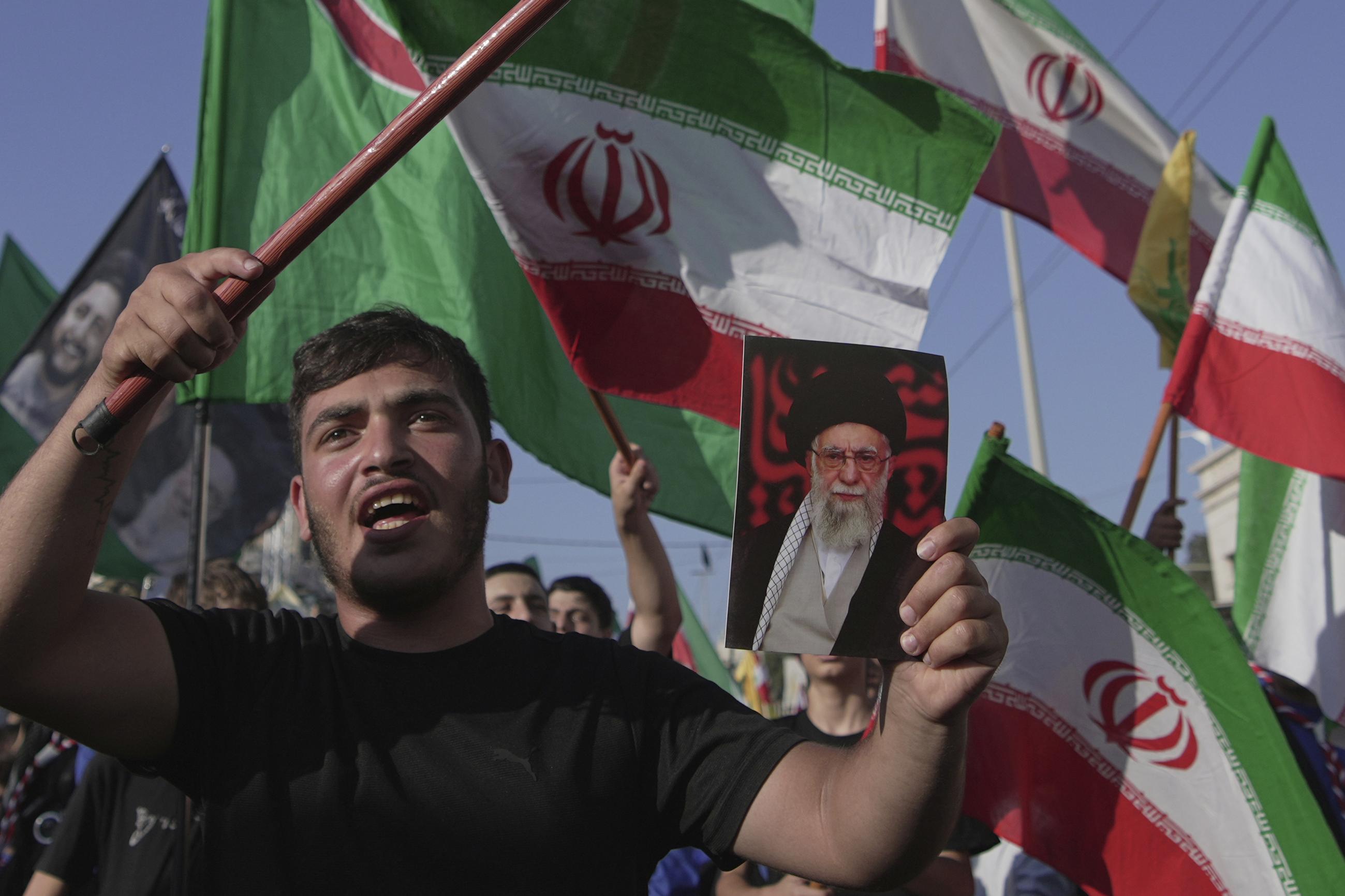 A Hezbollah supporter chants slogans and holds a portrait of Iran Supreme Leader Ayatollah Ali Khamenei during a gathering outside the Iranian Embassy in Beirut on June 25 to honor the Islamic Republic of Iran for what organizers described as "breaking American and Israeli aggression." (AP Photo/Hassan Ammar)