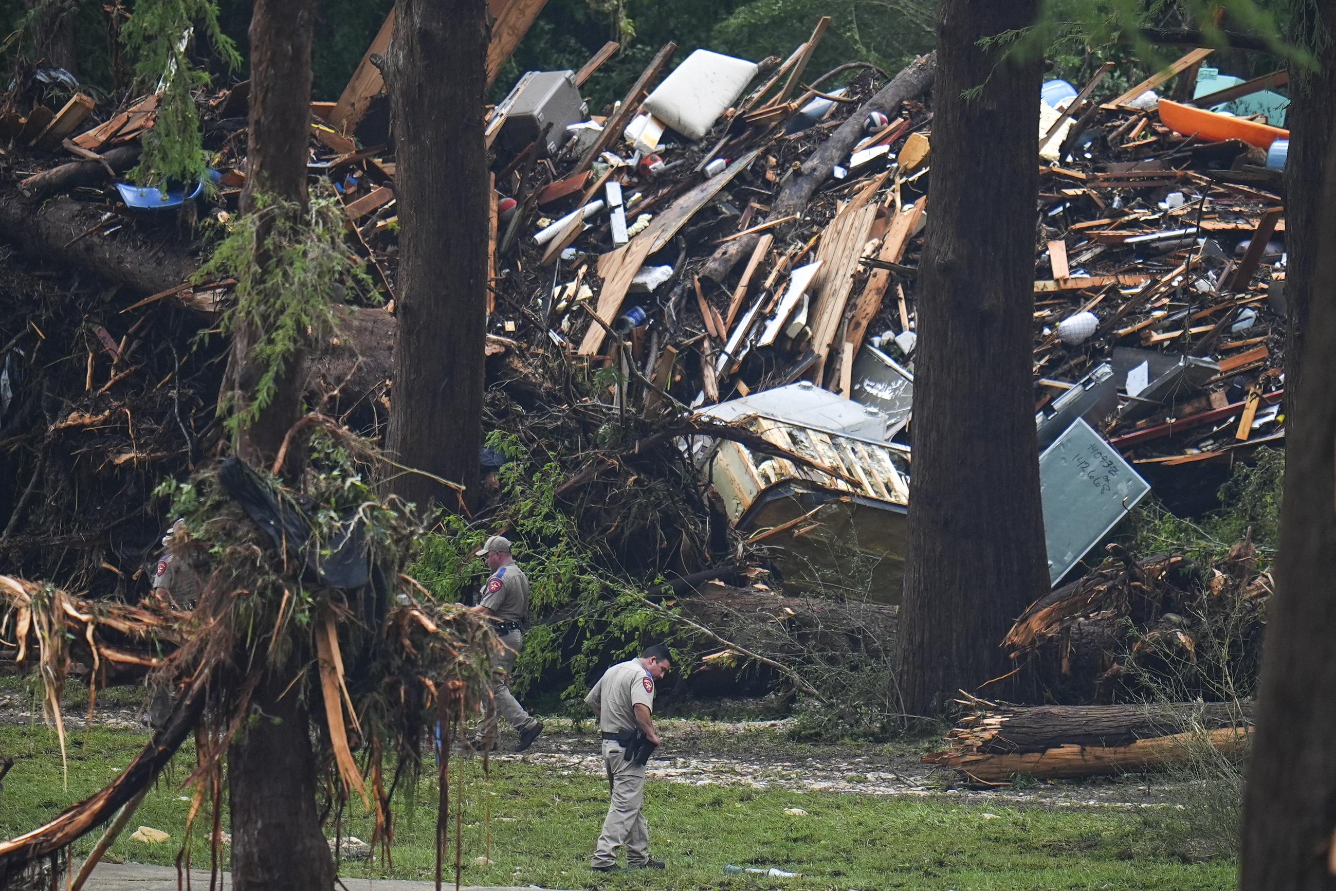 Officials examine debris near the Guadalupe River after a flash flood swept through the area on July 4. (AP Photo/Julio Cortez)