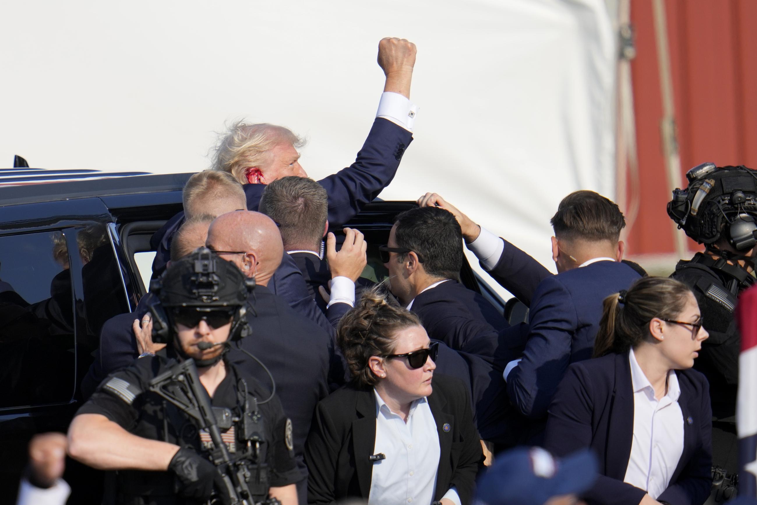 FILE - Republican presidential candidate former President Donald Trump is escorted to a motorcade following an attempted assassination at a campaign event in Butler, Pa., July 13, 2024. (AP Photo/Gene J. Puskar, File)