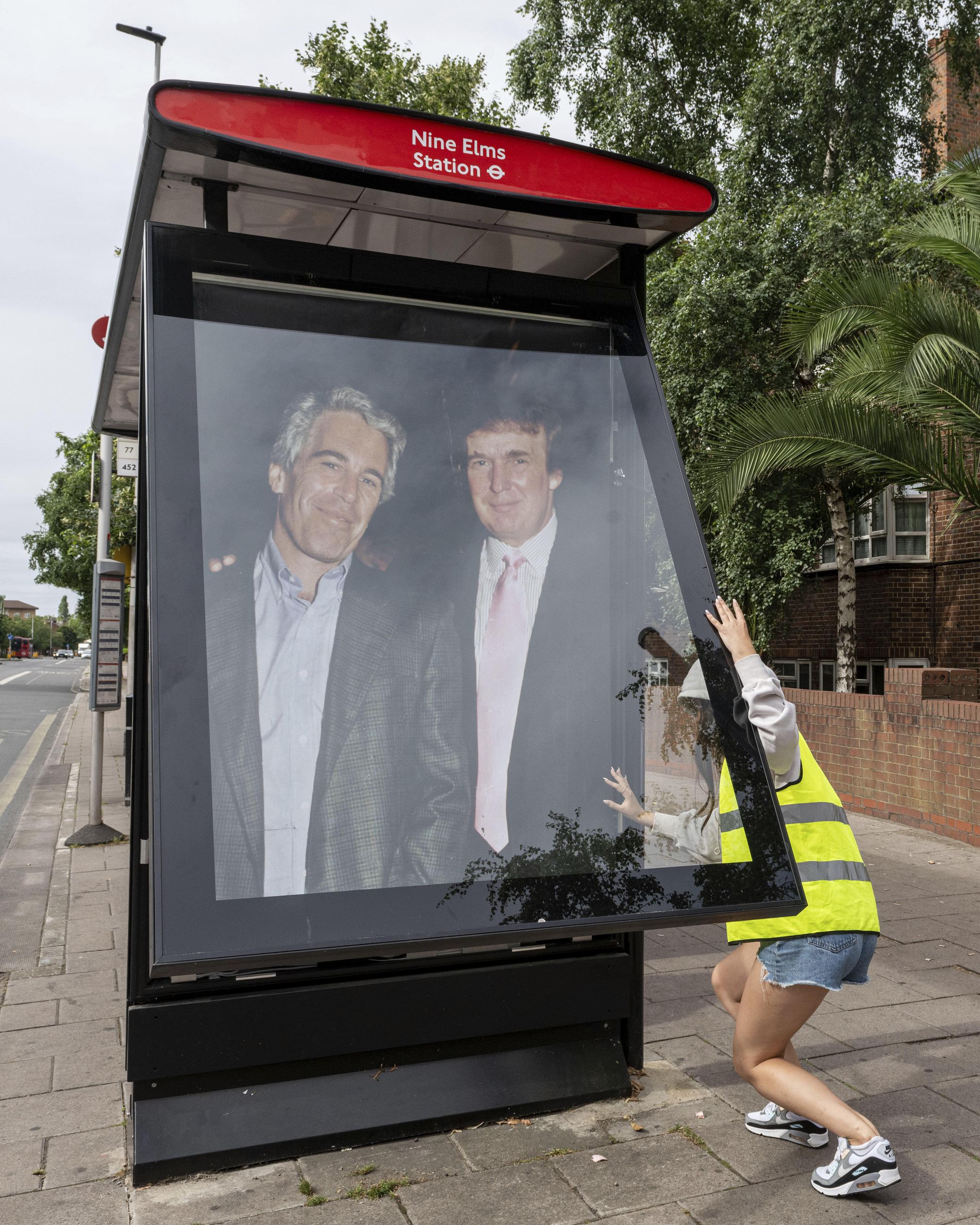 Activists put up a poster showing President Trump and Jeffrey Epstein near the U.S. Embassy in London on July 17.(AP Photo/Thomas Krych)