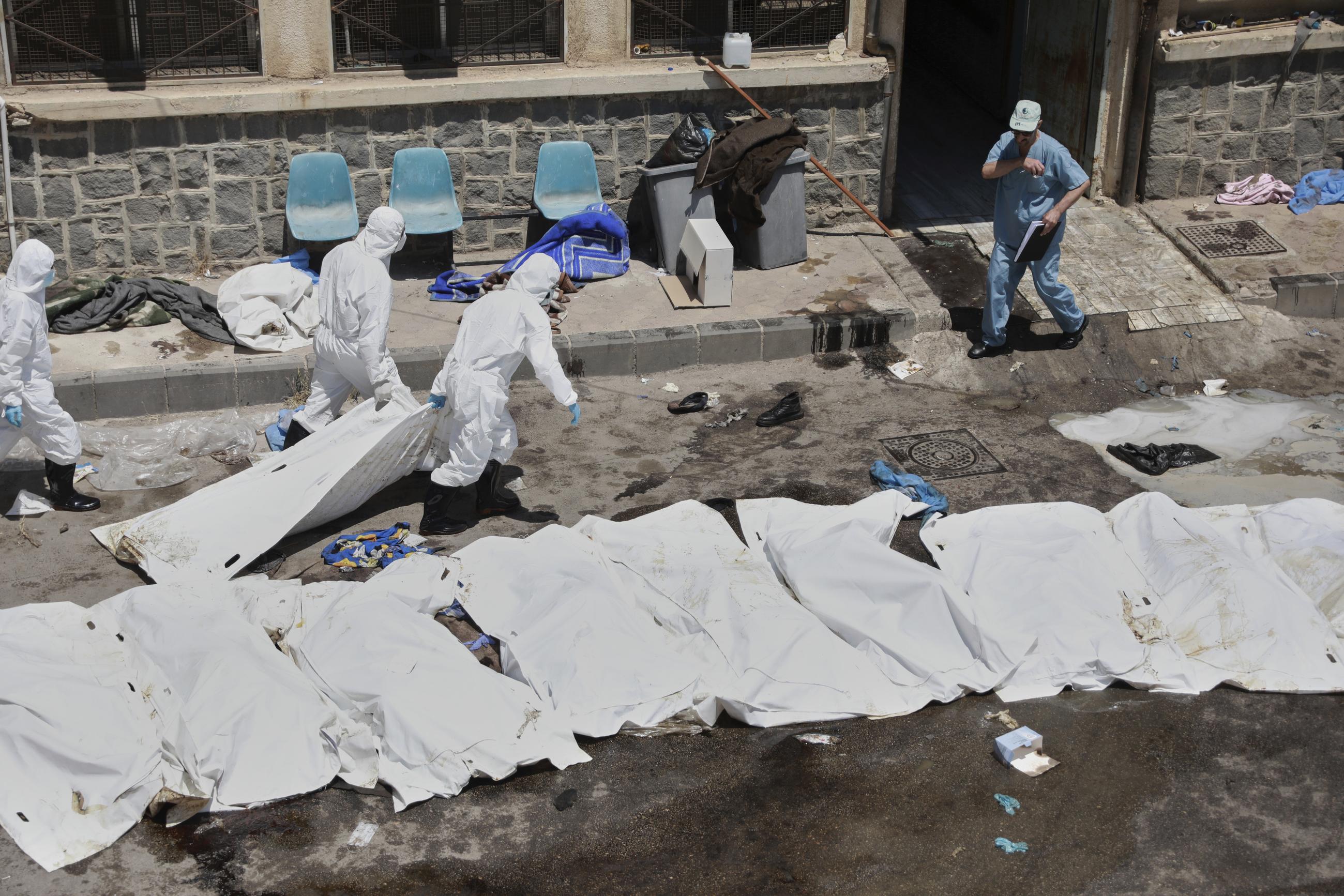 Morgue workers collect the bodies of unidentified people killed during clashes between Bedouin clans and Druze militias in Sweida, Syria, July 21, 2025. (AP Photo/Fahd Kiwan)