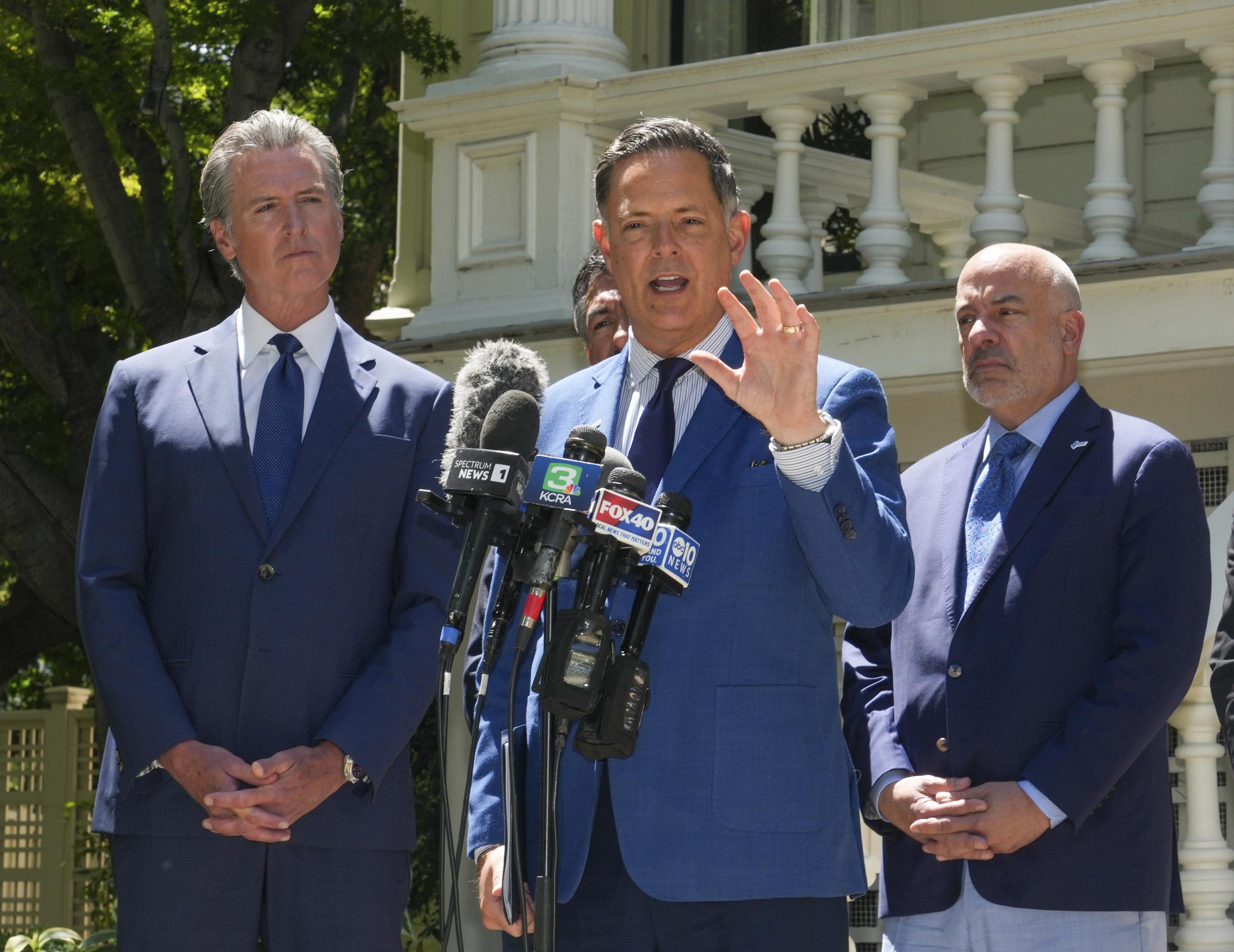 California Gov. Gavin Newsom, left, listens as Texas state Representative Rafael Anchia, center discusses the Republican redistricting efforts in Texas, during a news conference In Sacramento, Calif., Friday July 25, 2025. (AP Photo by Rich Pedroncelli)