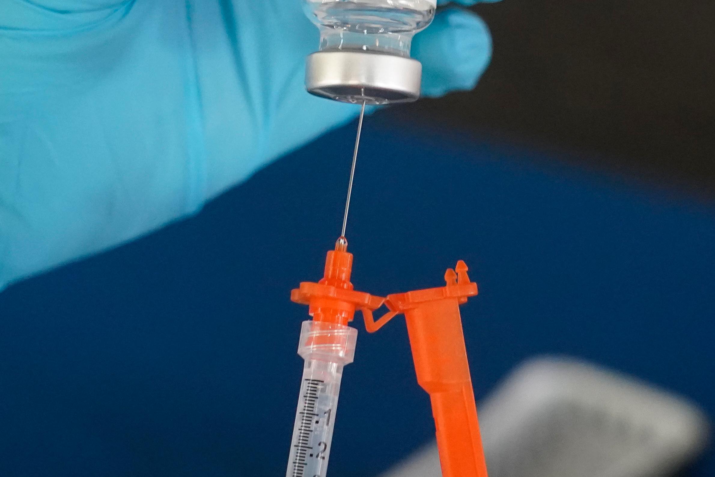 A nurse loads a syringe with a COVID-19 booster vaccine in 2022. (AP Photo/Rogelio V. Solis, File)