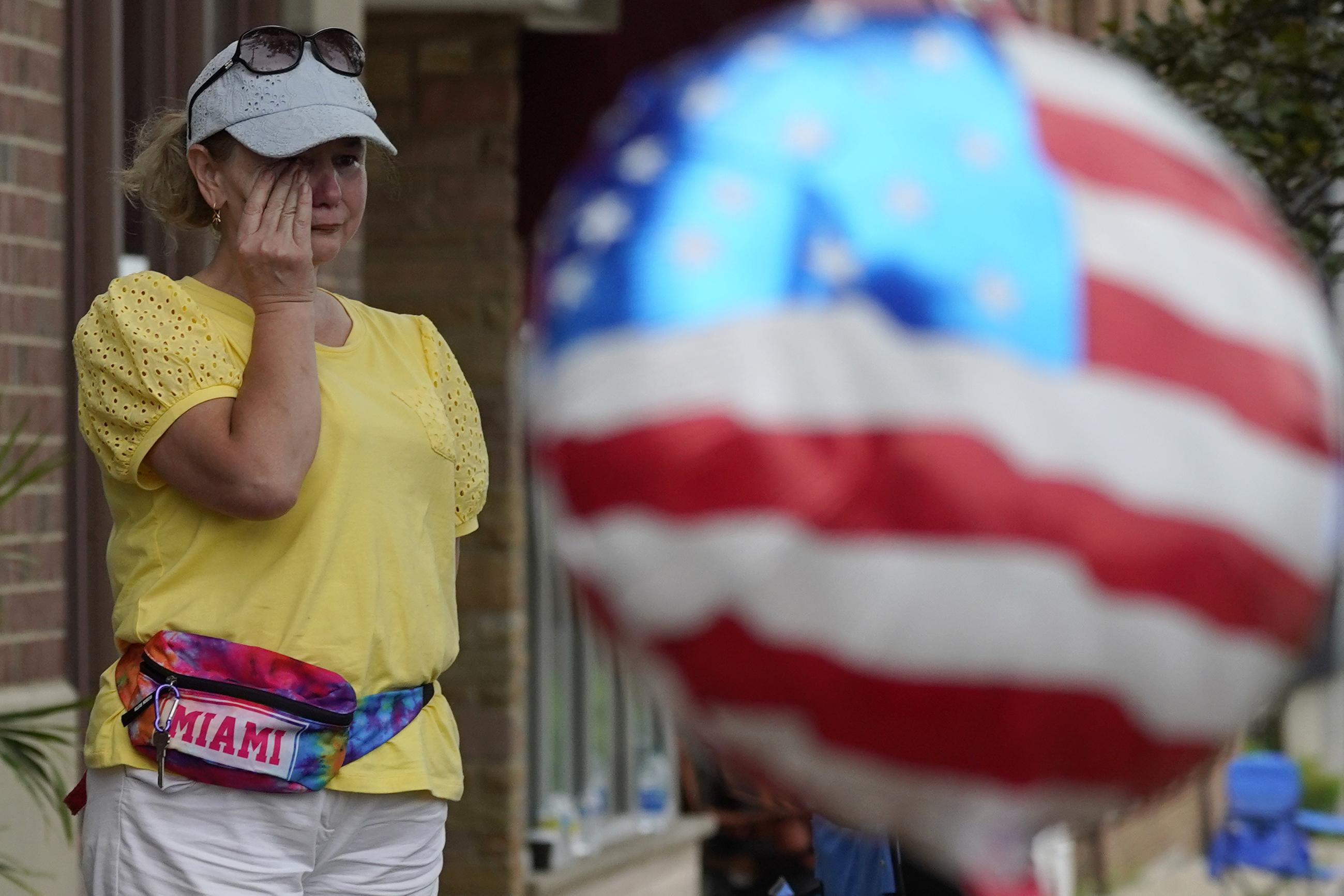 A woman wipes away tears after a mass shooting at an Independence Day parade in the Chicago suburb of Highland Park in 2022. (AP Photo/Nam Y. Huh)