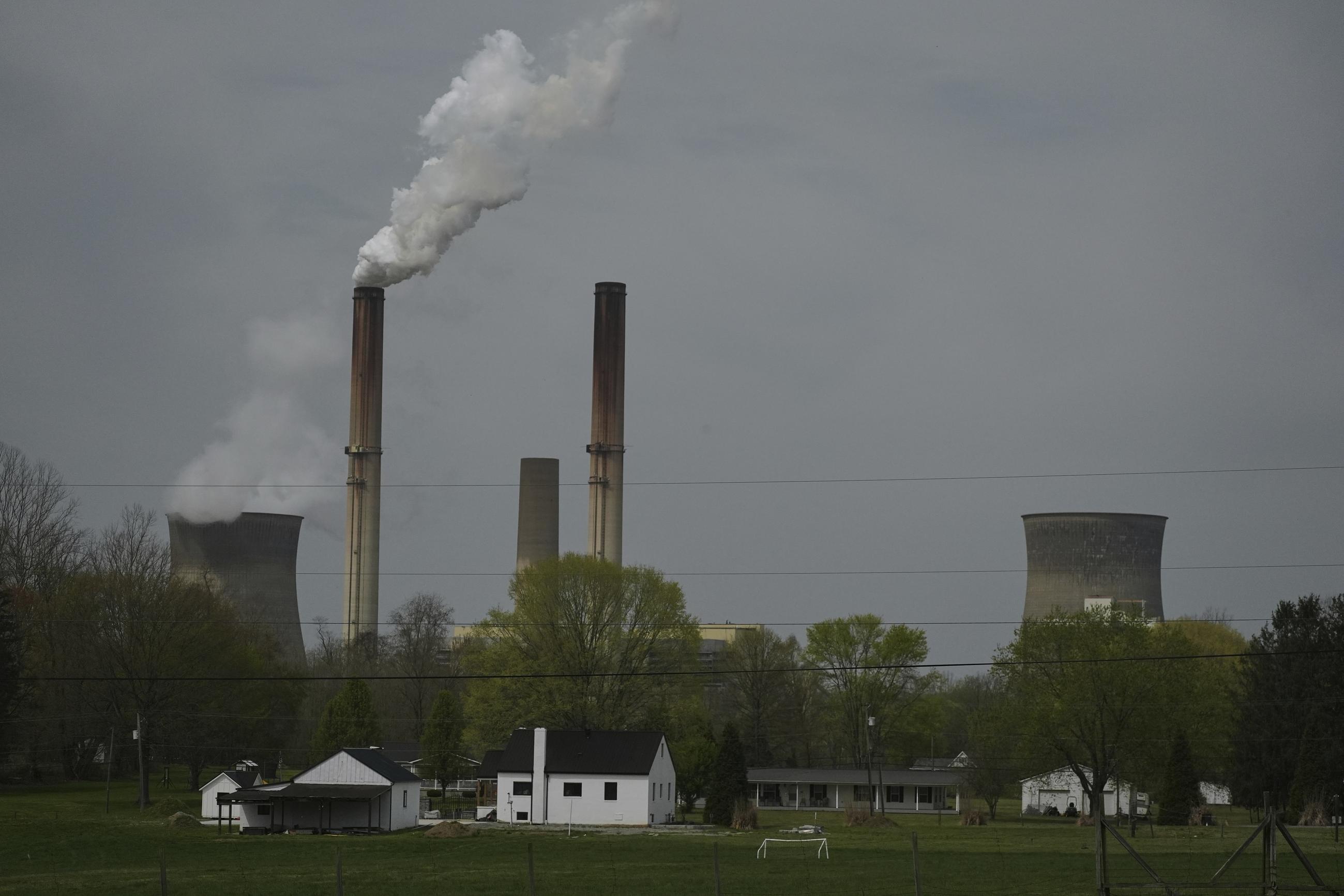 FILE - A home sits near a coal-fired power plant in Point Pleasant, W.Va. (AP Photo/Joshua A. Bickel, File)