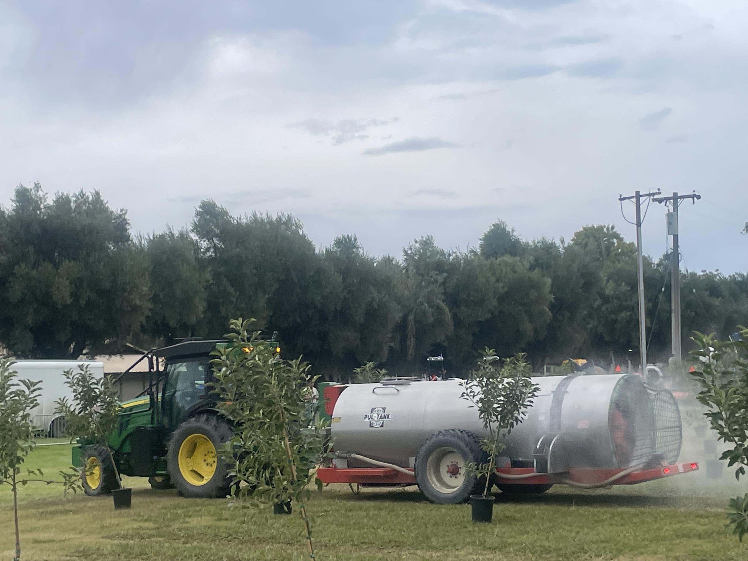 A John Deere autonomous tractor and a sprayer that would be used in an orchard pass between small trees in a demonstration at a technology fair in Woodland, Calif. (National Journal/Jerry Hagstrom)