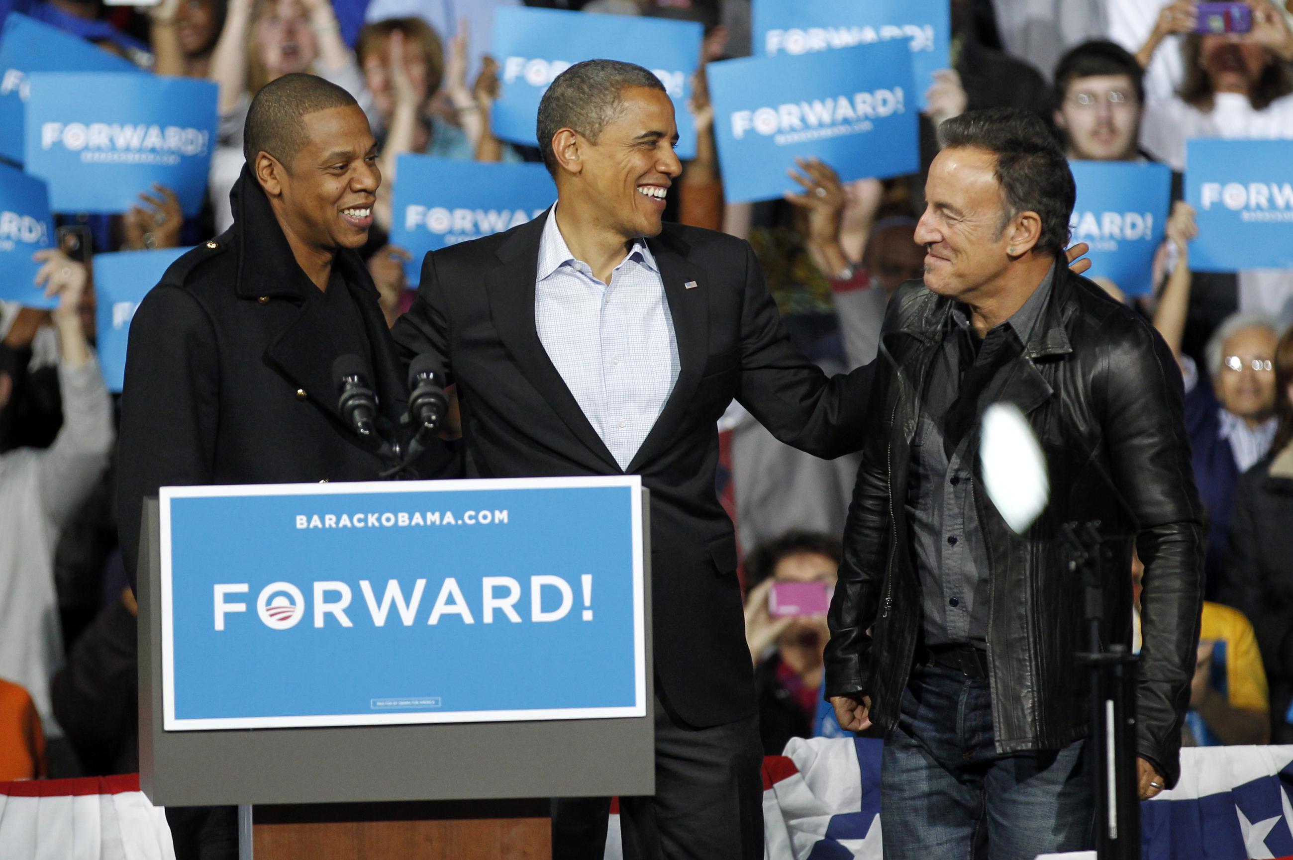 Jay-Z, left to right, President Barack Obama and Bruce Springsteen smile during a campaign event at Nationwide Arena Monday, Nov. 5, 2012, in Columbus, Ohio. (AP Photo/Tony Dejak)