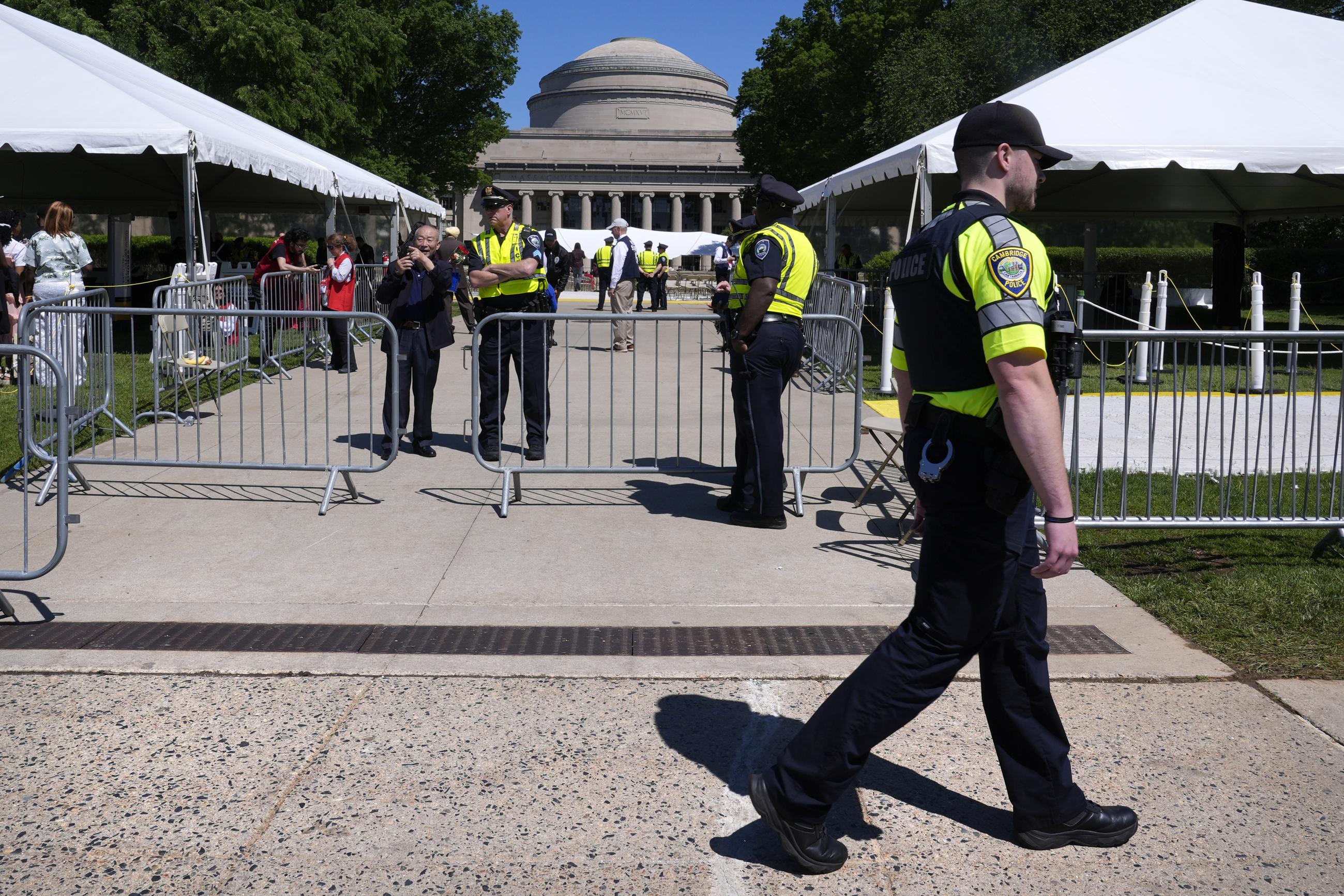 A Cambridge, Mass., police officer walks past campus police officers at the security perimeter gates outside a commencement ceremony at the Massachusetts Institute of Technology in 2024. (AP Photo/Charles Krupa)