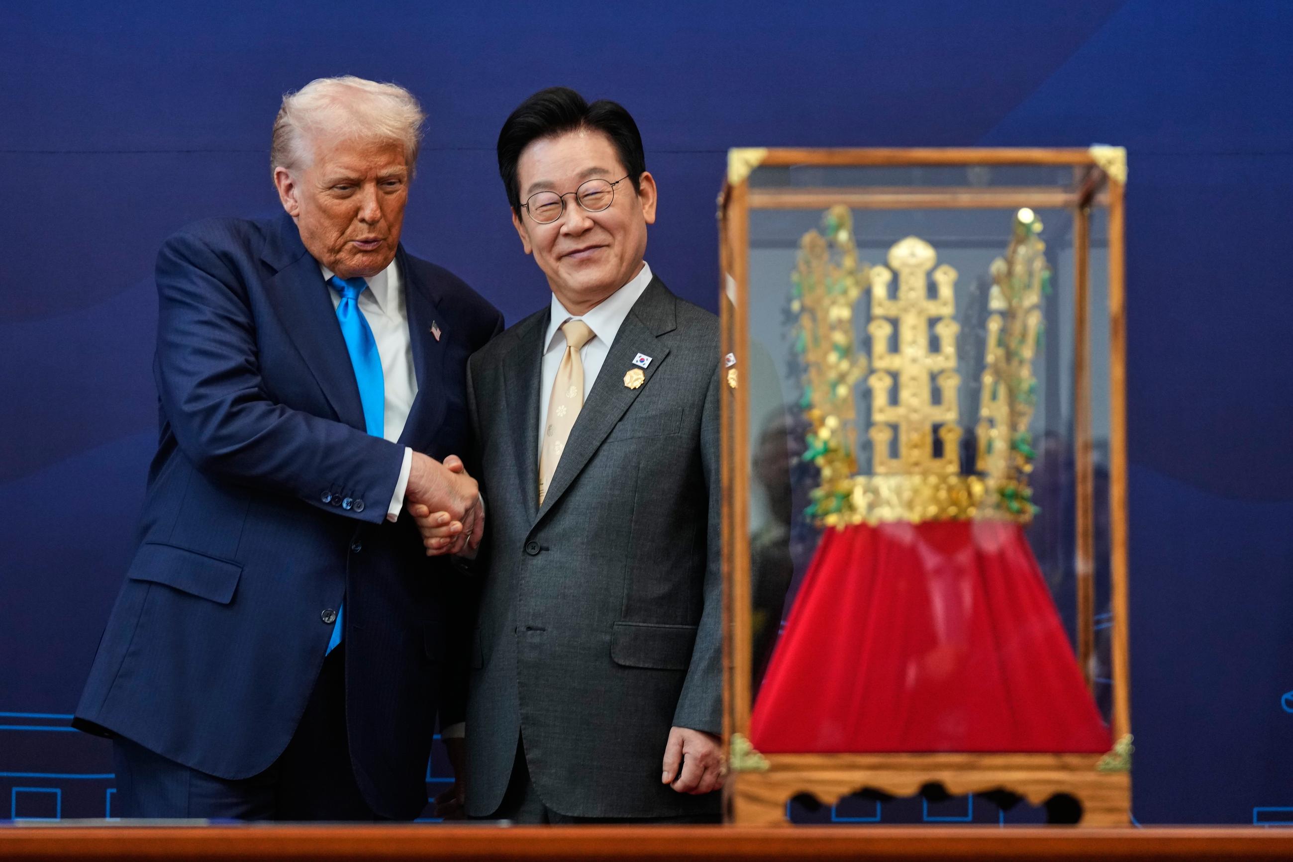 President Trump shakes hands with South Korean President Lee Jae Myung as he receives a gift of a gold crown and an award of the Grand Order of Mugunghwa (not seen) during a ceremony in Gyeongju, South Korea, on Wednesday. (AP Photo/Mark Schiefelbein)